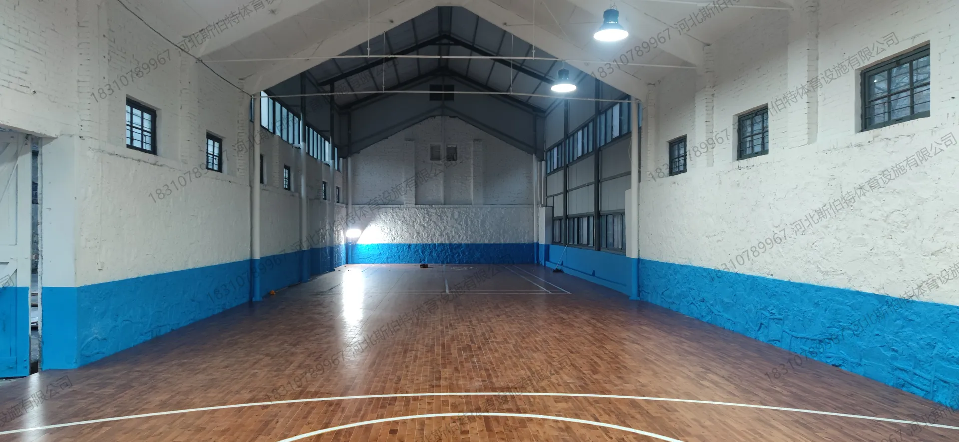 完工实景：枫桦木C级大节疤地板铺装完成，篮球场标线清晰，中圈与三分弧线完整