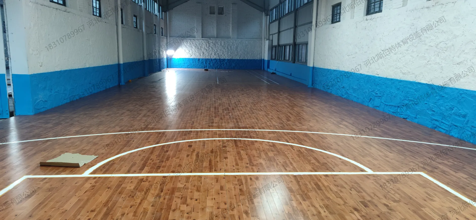 完工实景：深棕色枫桦木地板，天然节疤分布，反光均匀，篮球场标线白色清晰