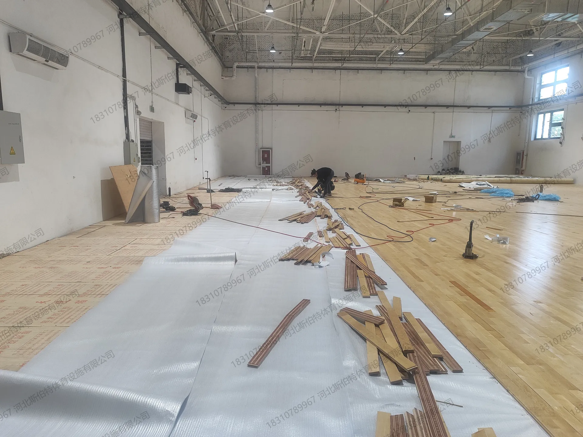 施工中期现场：材料沿墙堆放，中央留出作业通道