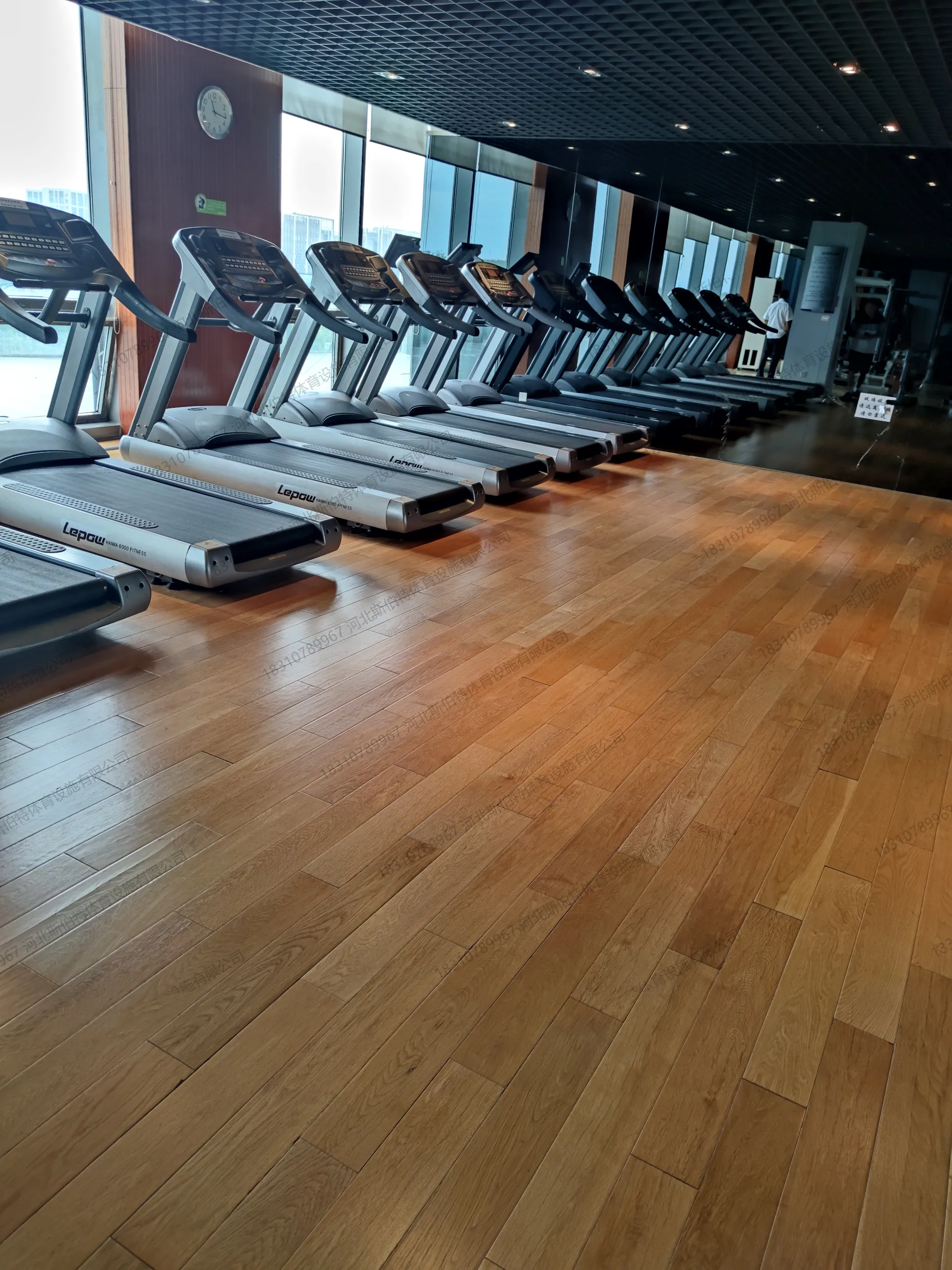 健身房完工实景：枫桦木地板搭配跑步机阵列，落地窗采光