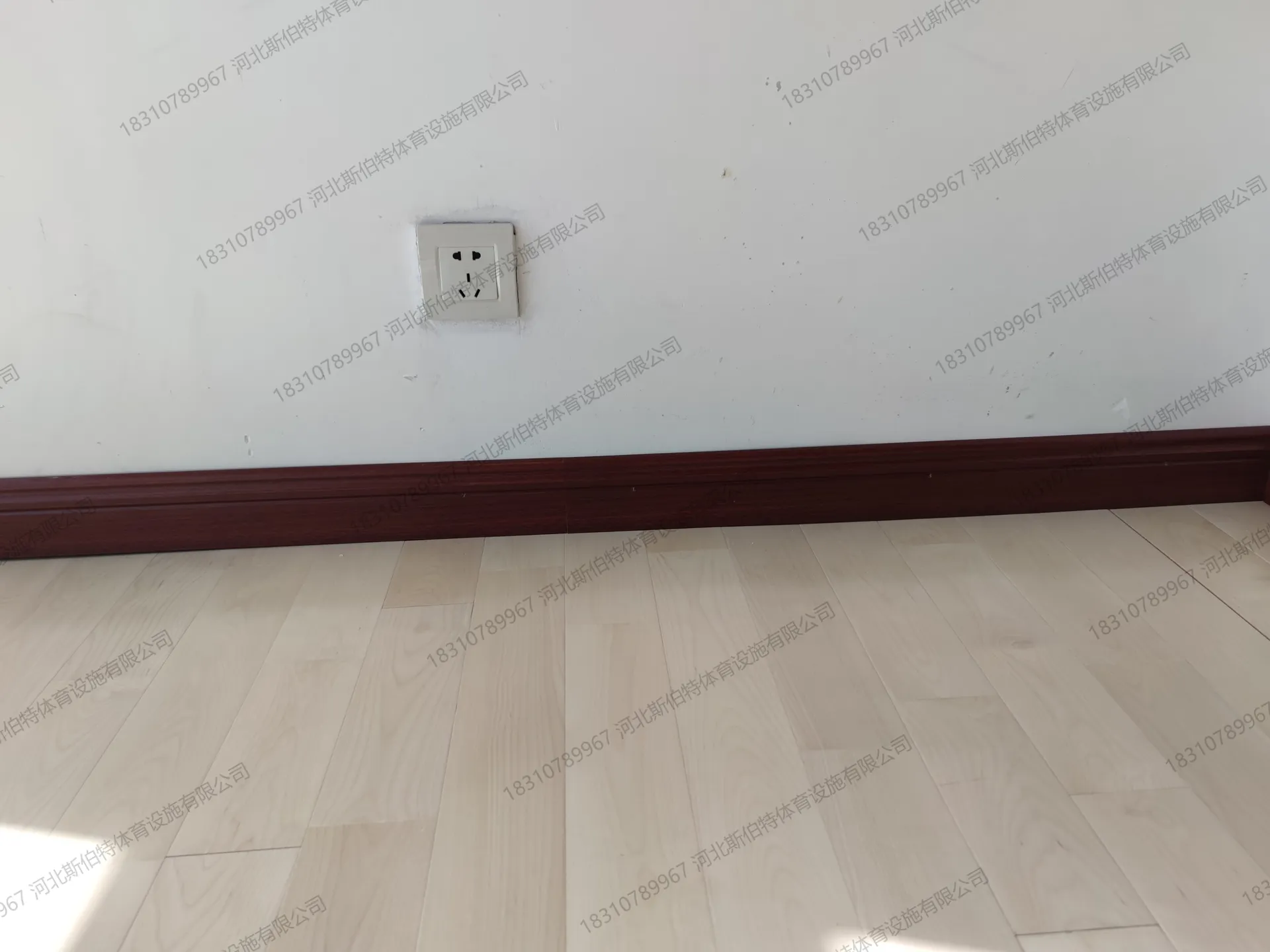 完工实景：浅色地板光洁，深色踢脚线收边