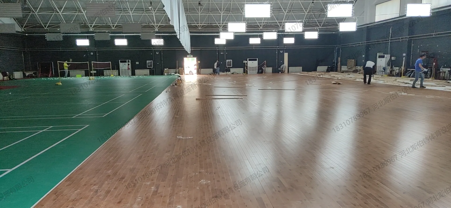 收尾阶段全景:新铺枫桦木地板与相邻绿色羽毛球场地分区明确