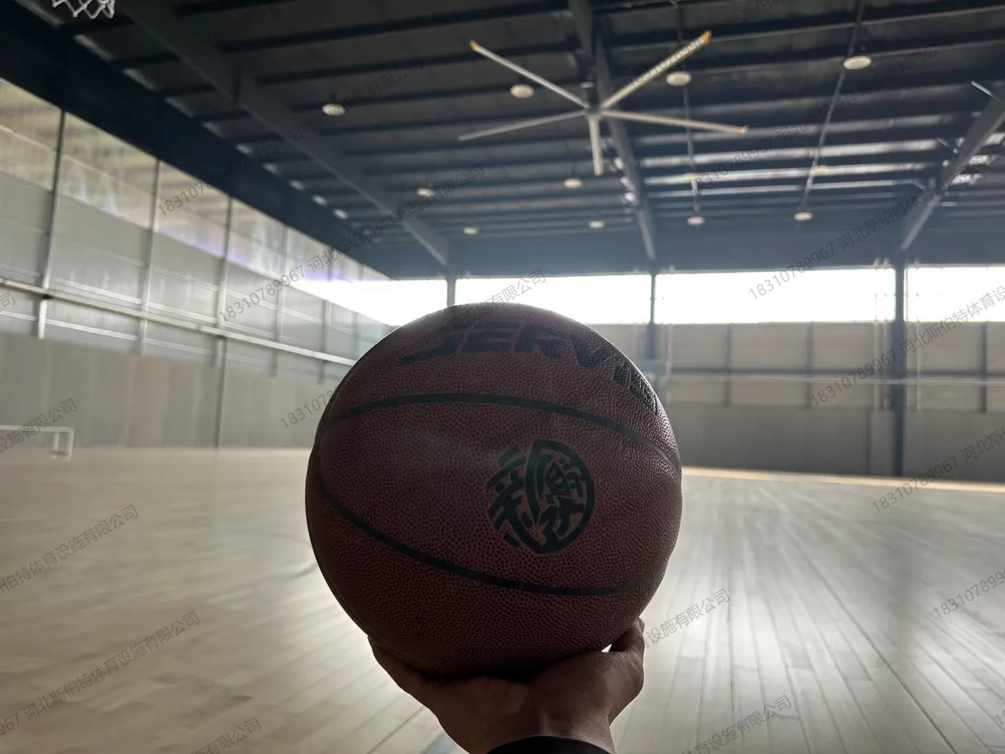 完工实景：木地板篮球场与地胶羽毛球场双功能区，标线清晰