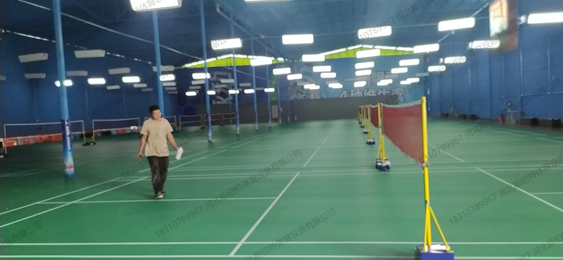 完工图：深绿色PVC运动地胶，白色标线，金属屋顶桁架