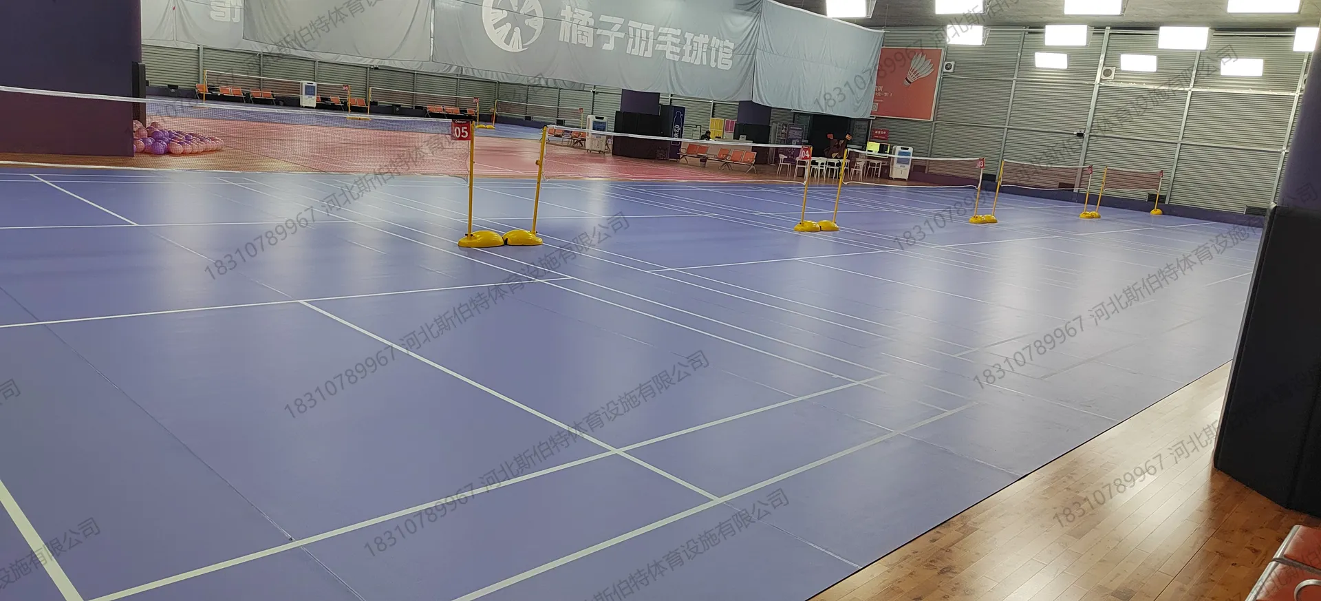 完工全景：蓝色地胶05号场地，橘子羽毛球馆横幅，黄色移动网柱