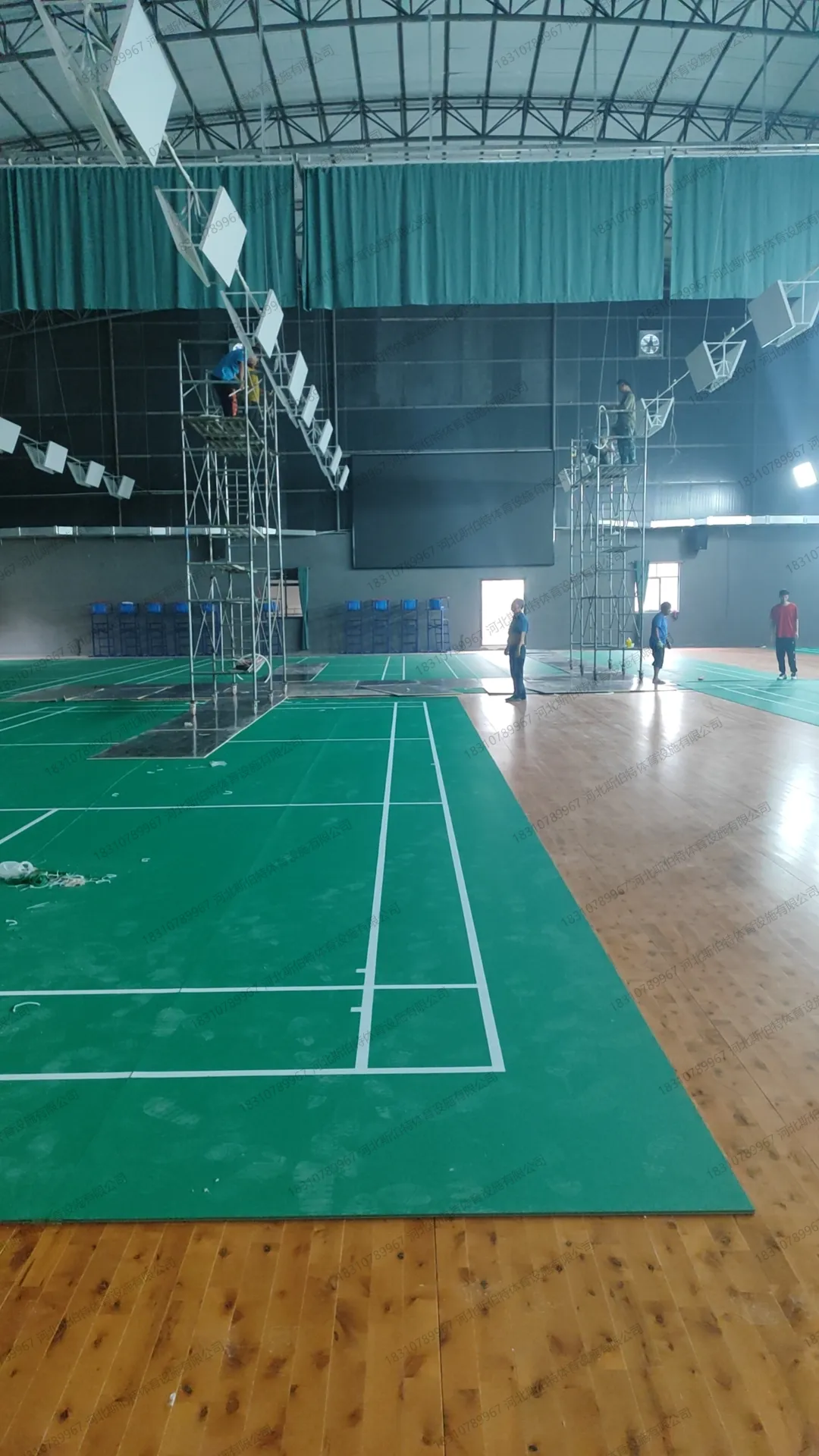 施工过程：木地板区与PVC地胶区拼接，工人在脚手架上作业