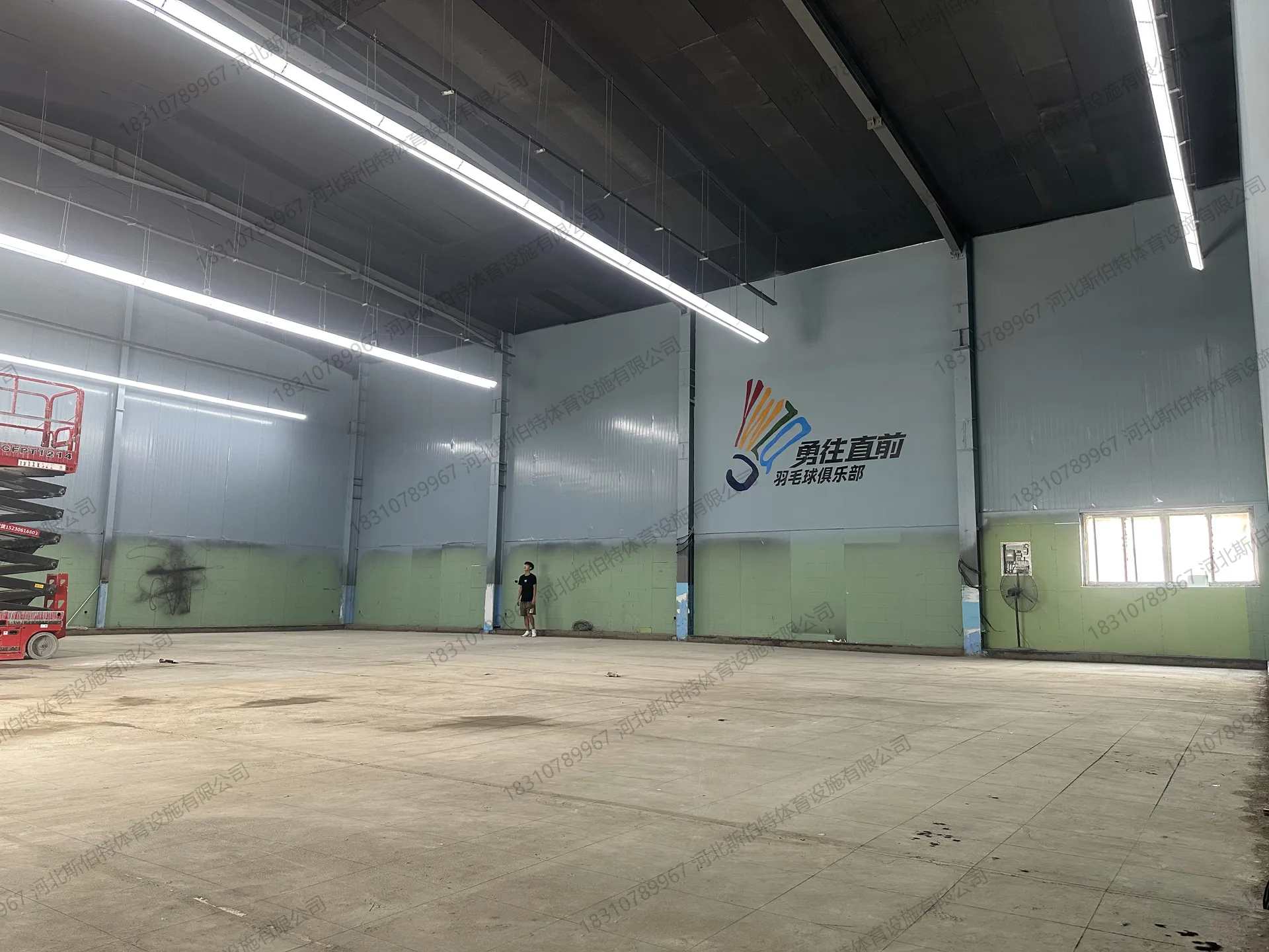 施工初期：毛坯水泥地面，升降机施工墙面，墙上有俱乐部Logo