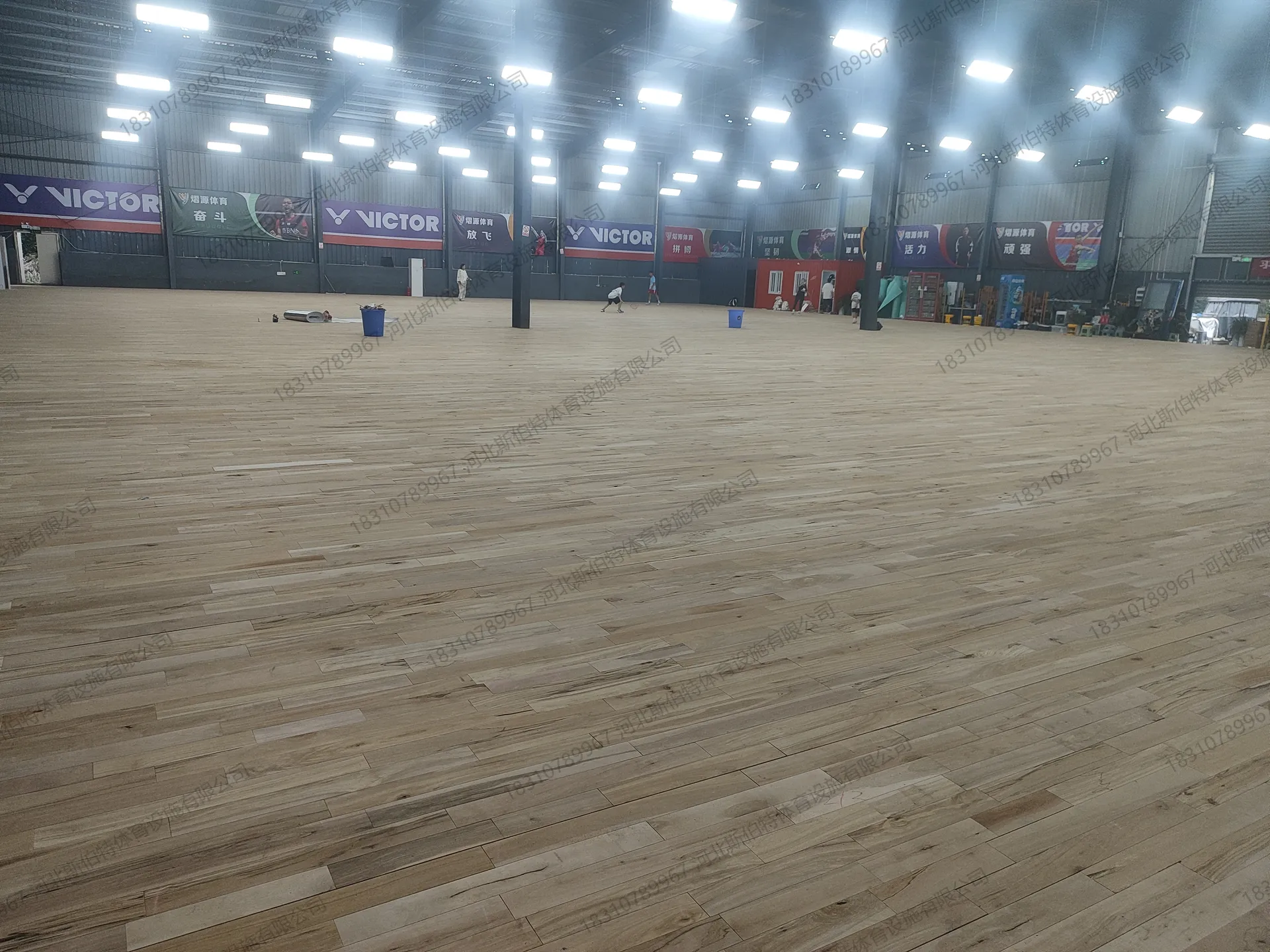 完工实景：枫桦木D级地板铺装完成，浅色木纹整洁，VICTOR品牌横幅悬挂
