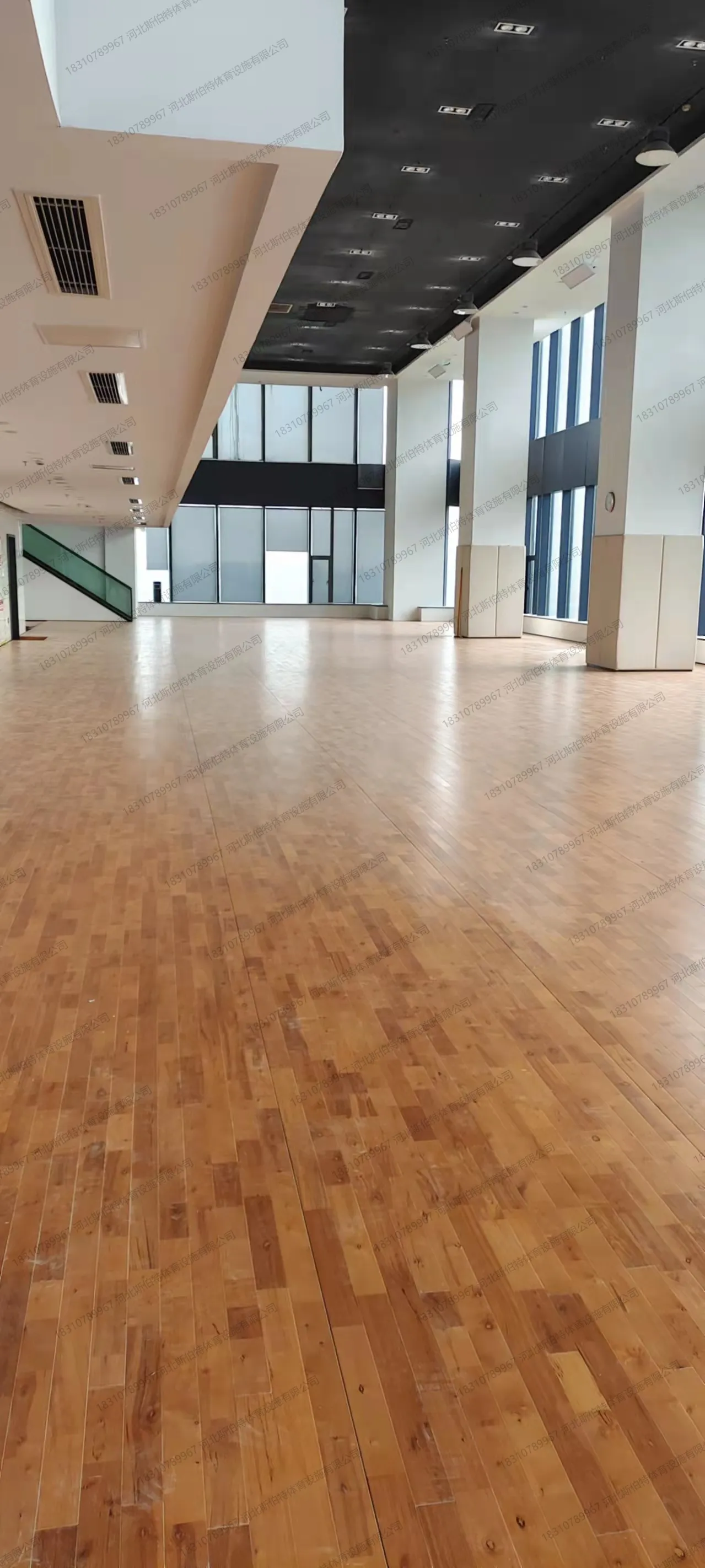 完工实景：枫桦木C级地板铺装完成，羽毛球场划线清晰，白色墙体黑色吊顶
