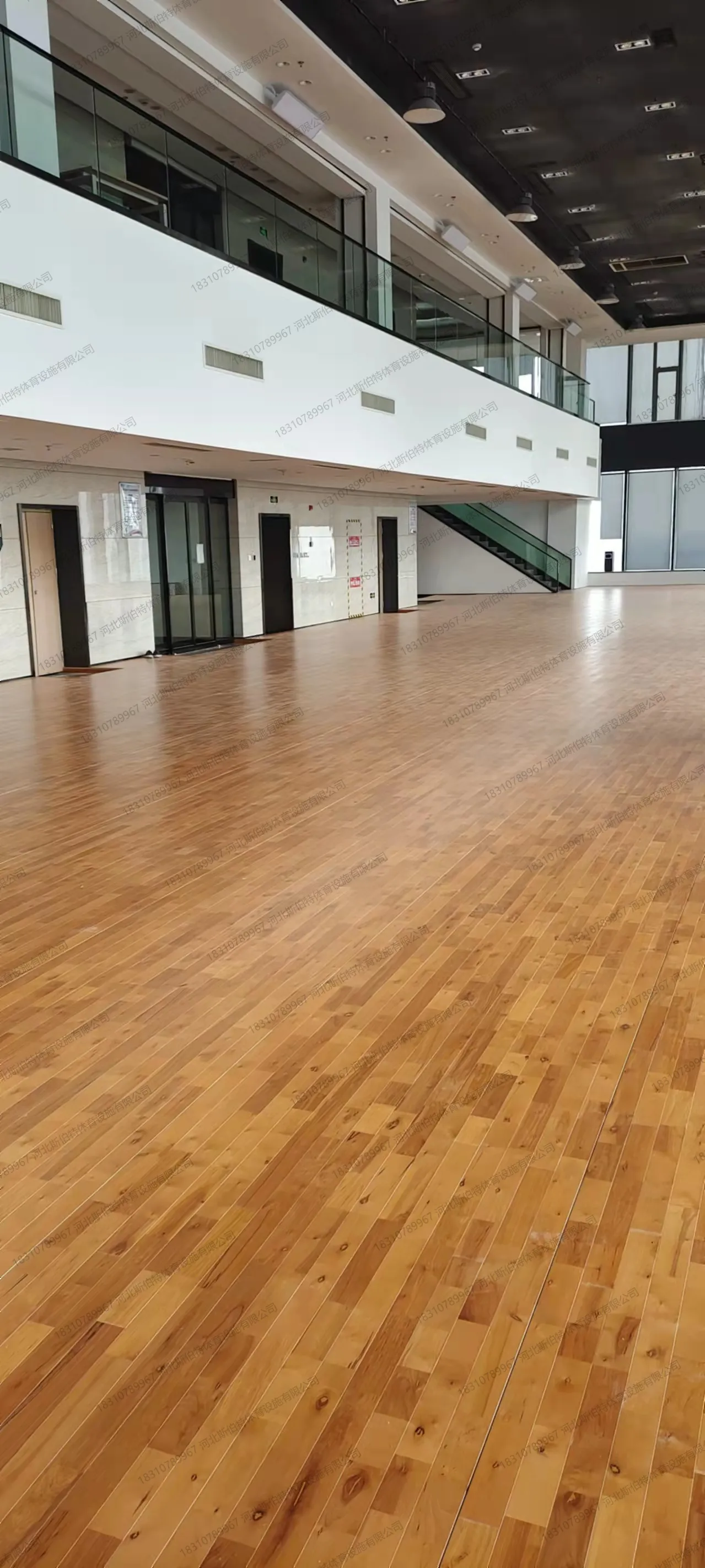 完工实景：羽毛球场地标线完整，场地开阔，落地窗采光充足