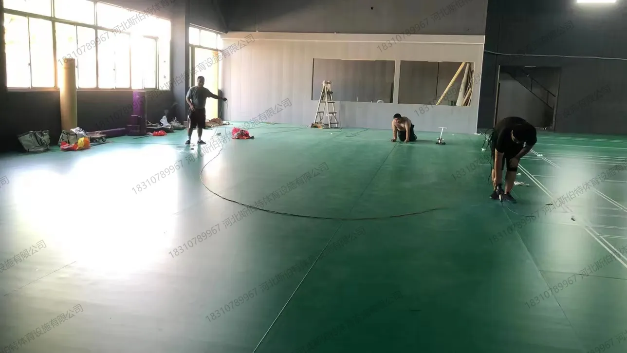 完工实景：绿色PVC地胶羽毛球场，运动员训练中