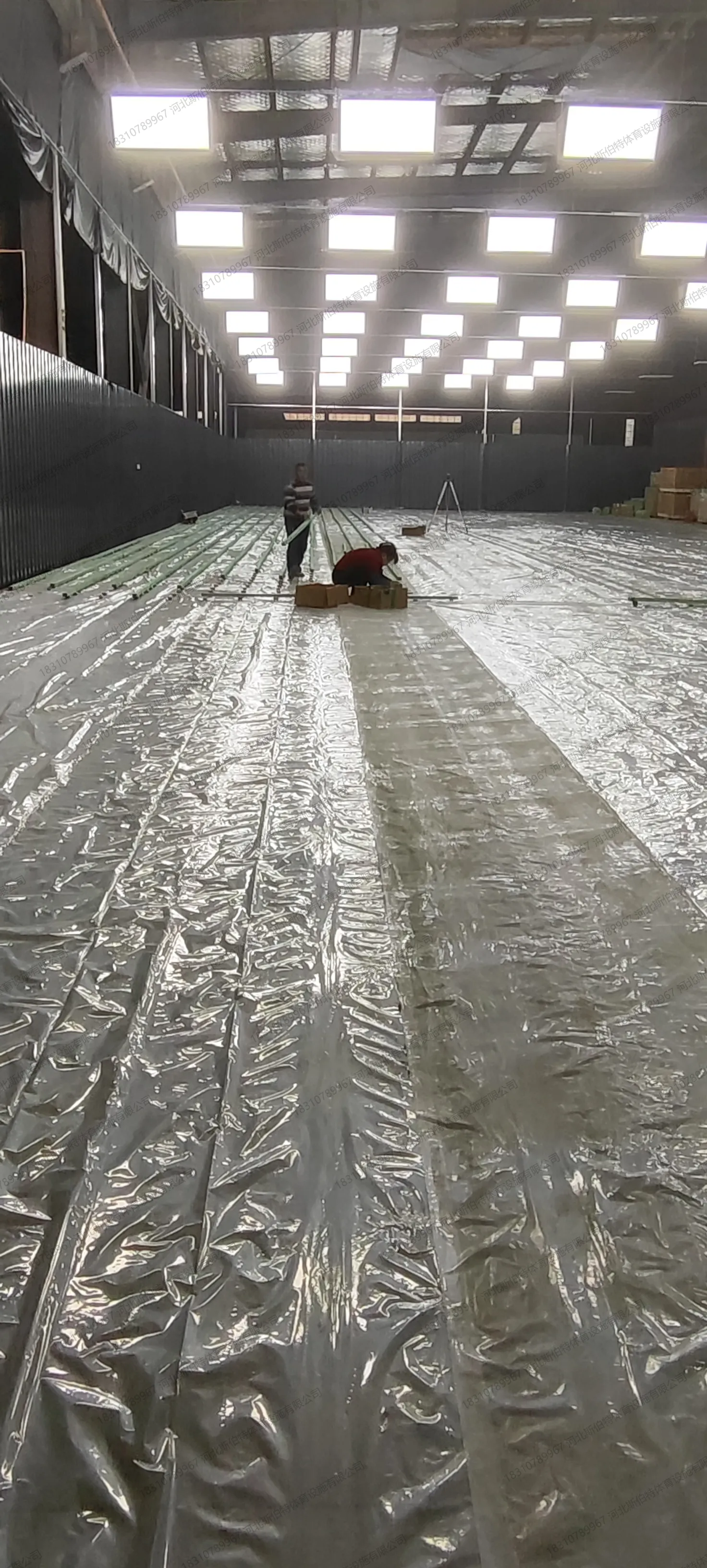 施工过程：基层处理与防潮层铺设阶段，场地逐步成型