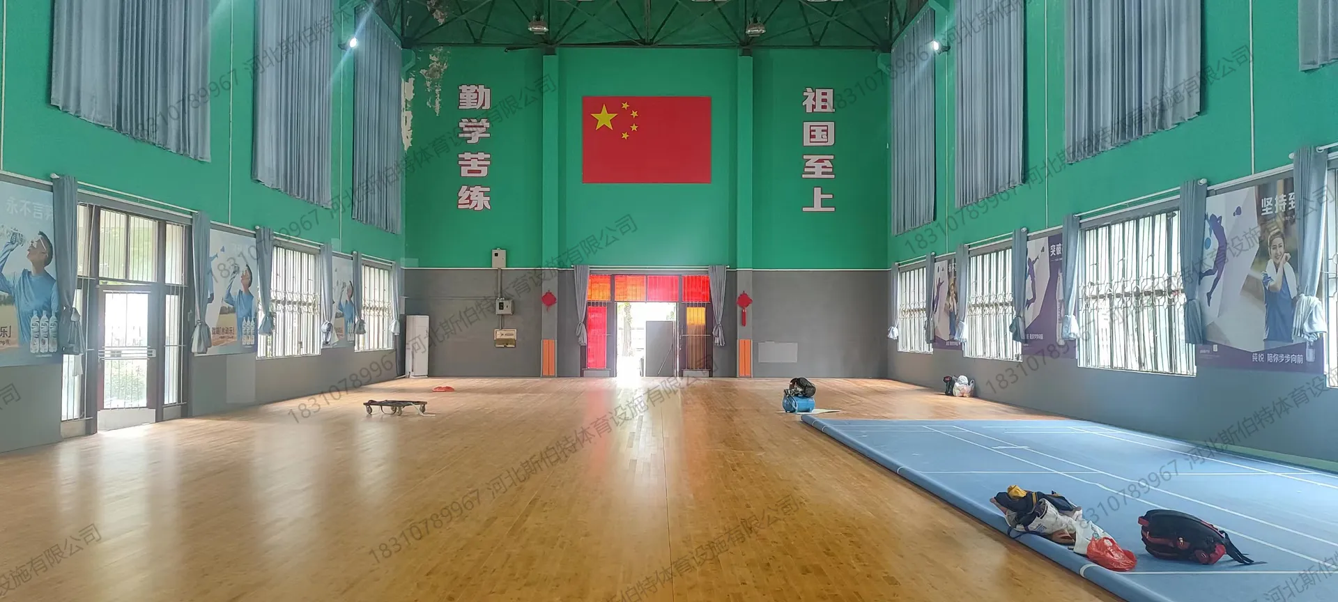 完工实景:木地板铺装完成,墙面"勤学苦练祖国至上"标语,国旗悬挂