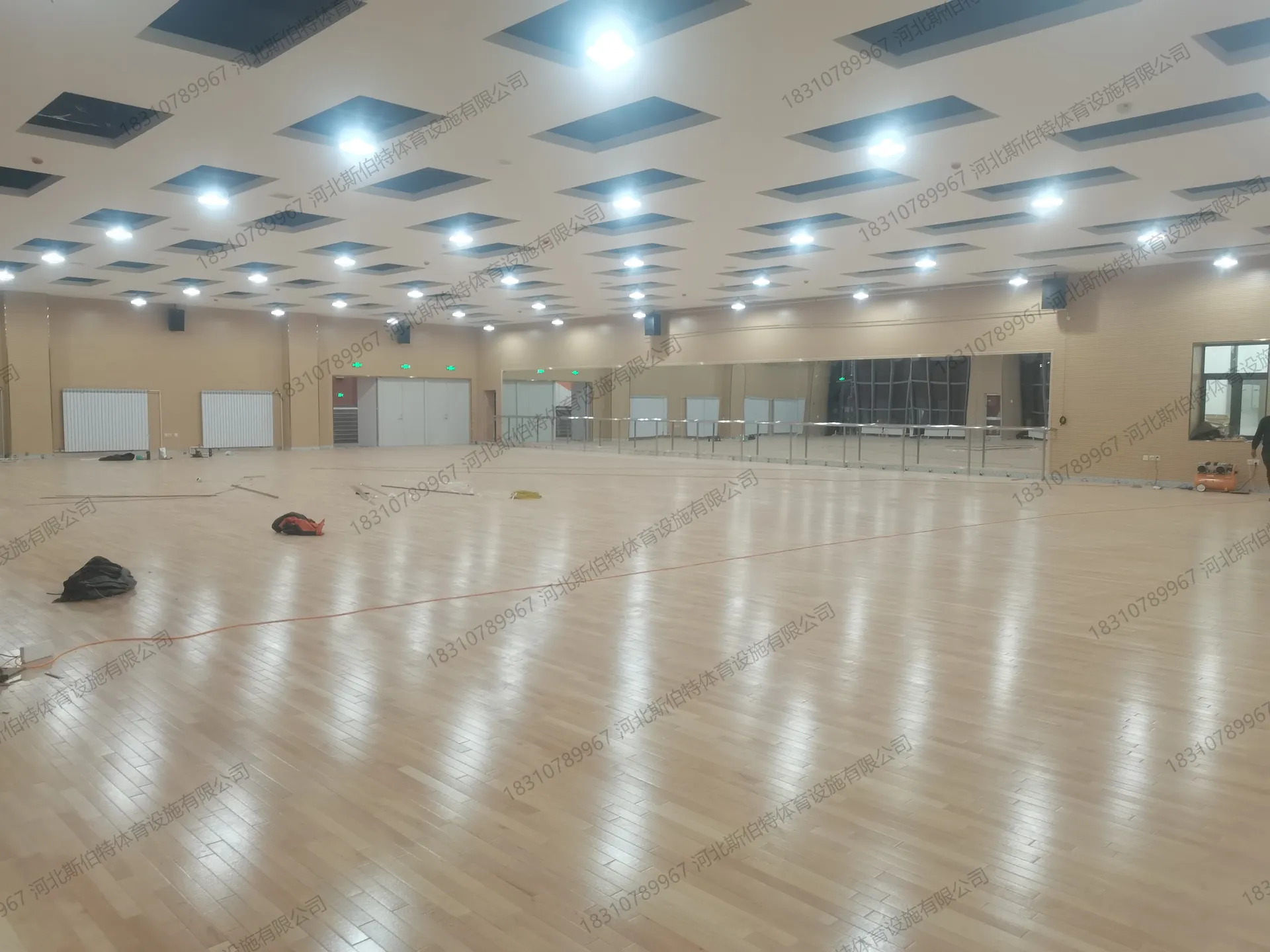 舞蹈把杆与地板：墙边安装舞蹈把杆，浅色原木色地板铺满