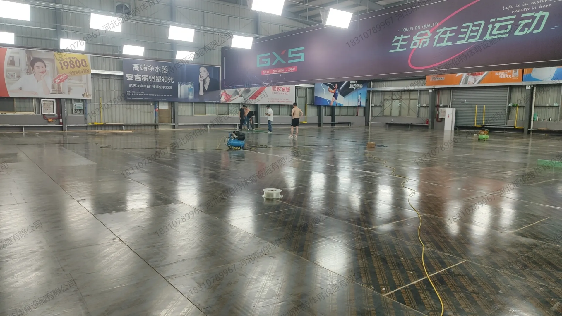 面板铺装收尾:面板铺完,地面有水渍反光,待划线
