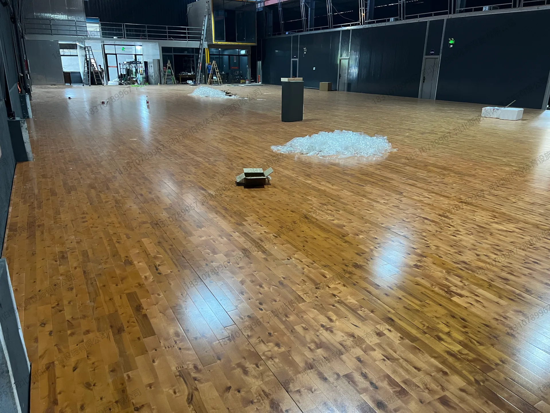 施工收尾：漆面光泽明显，灯管倒影清晰，场馆待划线交付