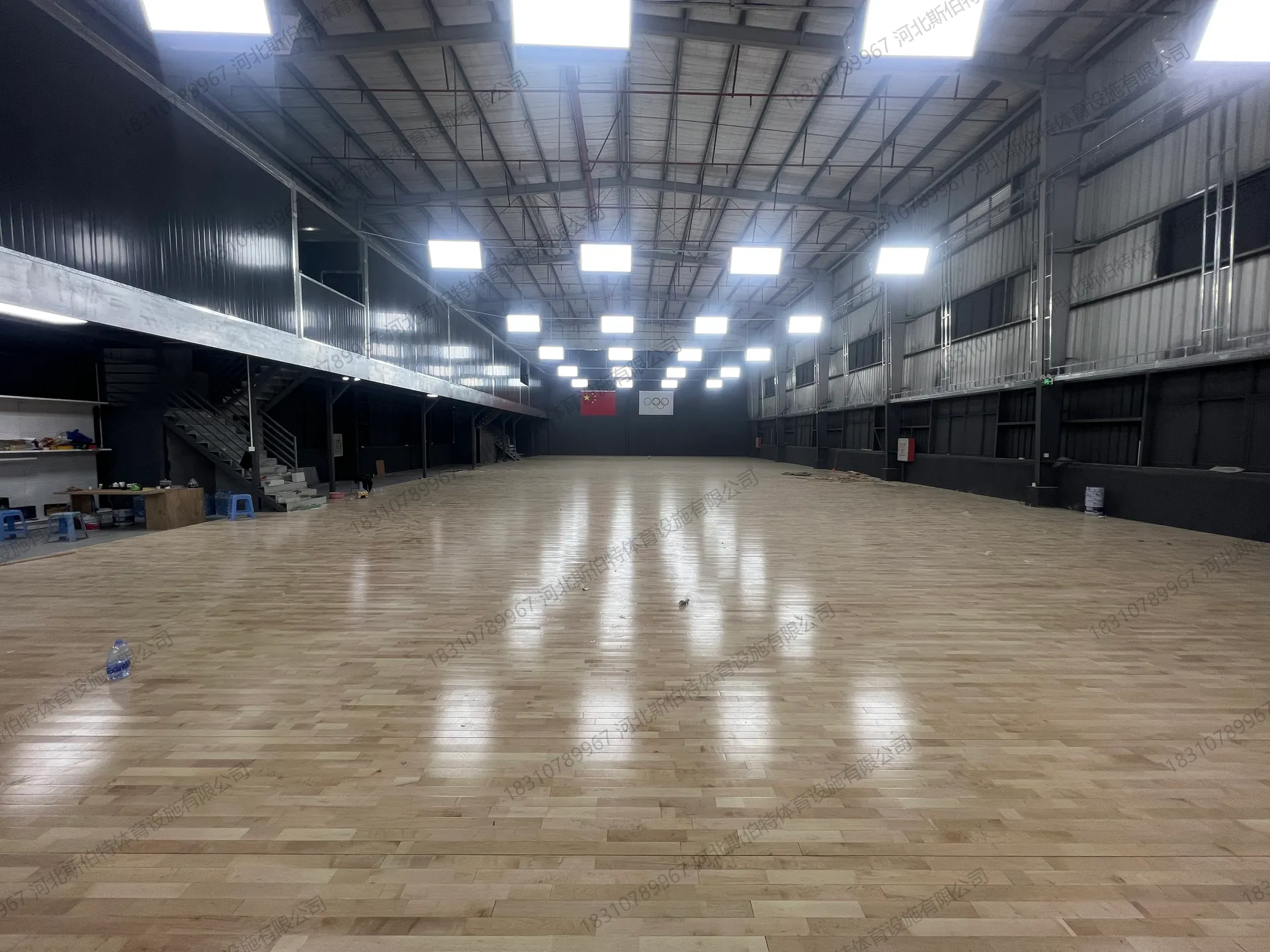 翻新完工实景：浅色枫桦木地板光洁如新，顶部LED灯阵均匀照明