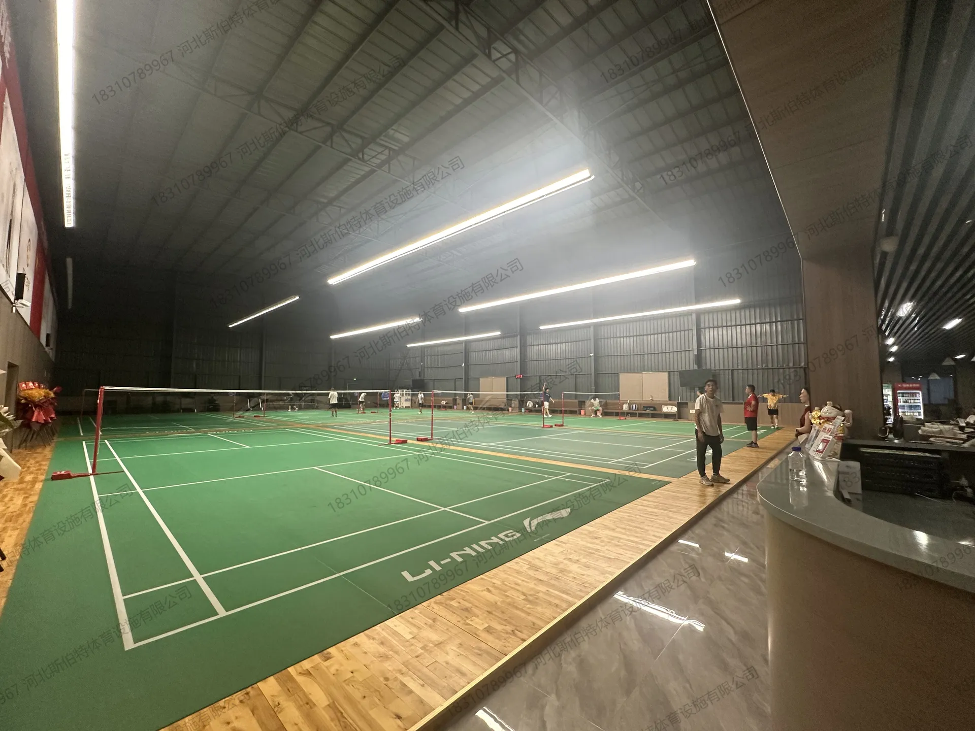 完工全景:6片以上羽毛球场地并排,服务台就位,场馆投入运营