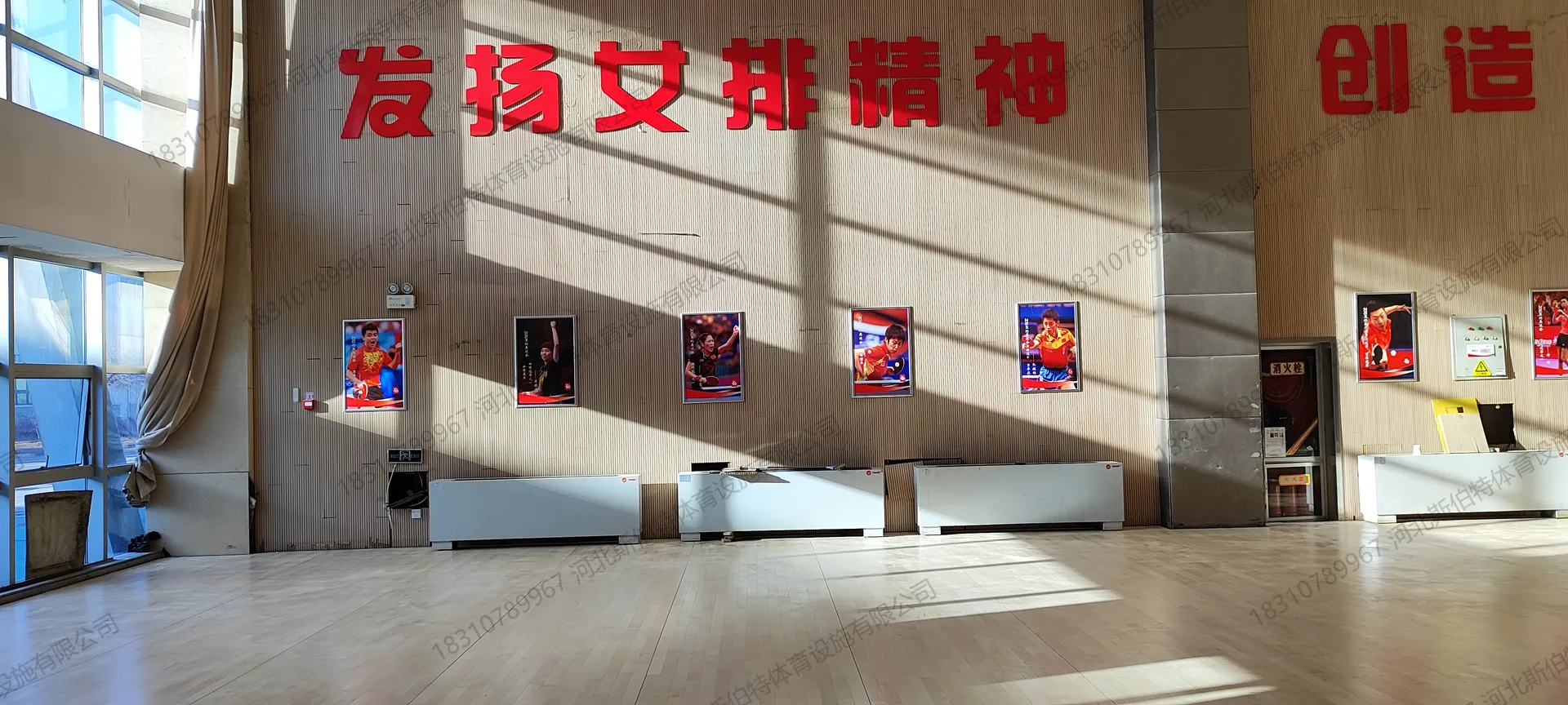 完工实景：墙面近景，乒乓球国手海报排列，"发扬女排精神"标语醒目