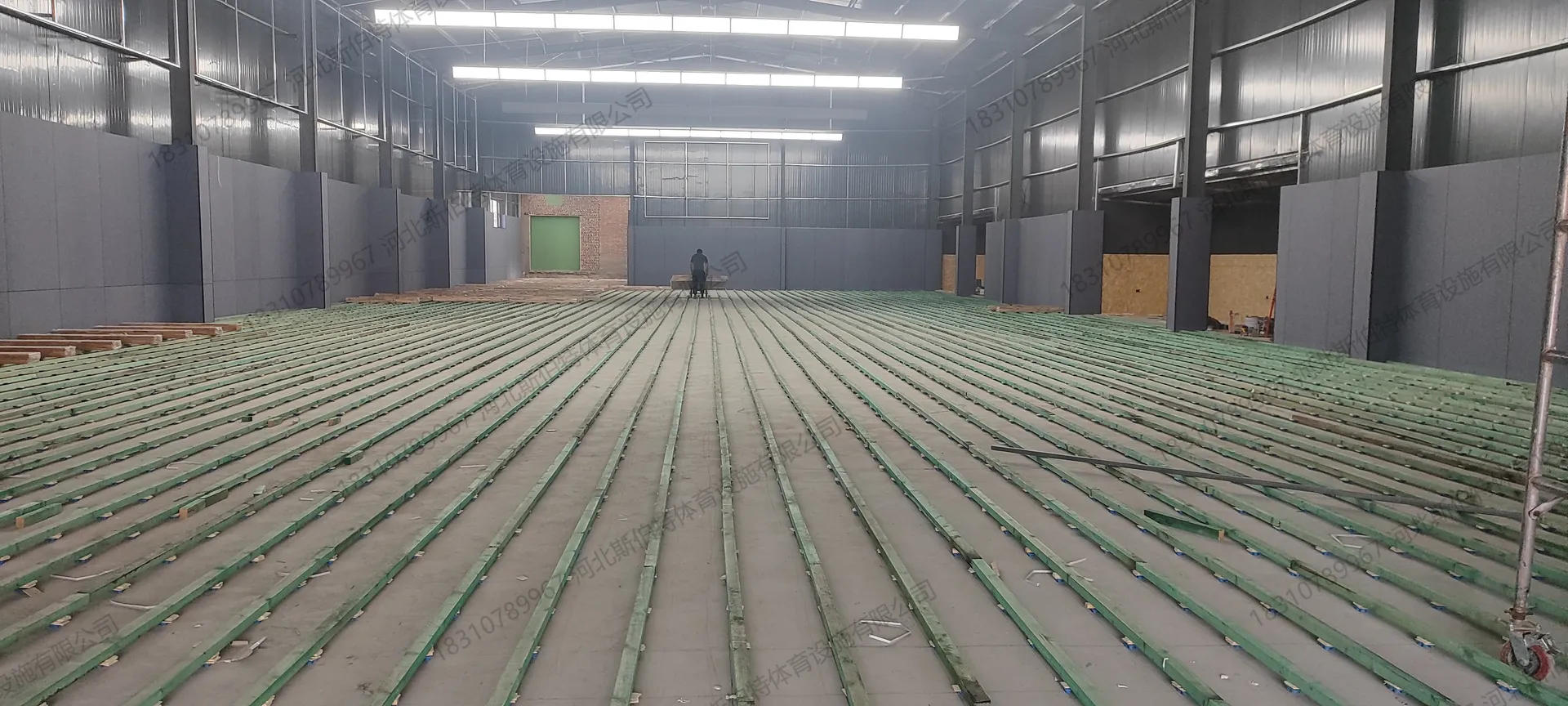 施工过程:龙骨安装完成,绿色防腐木龙骨网格状排列,减震垫调平