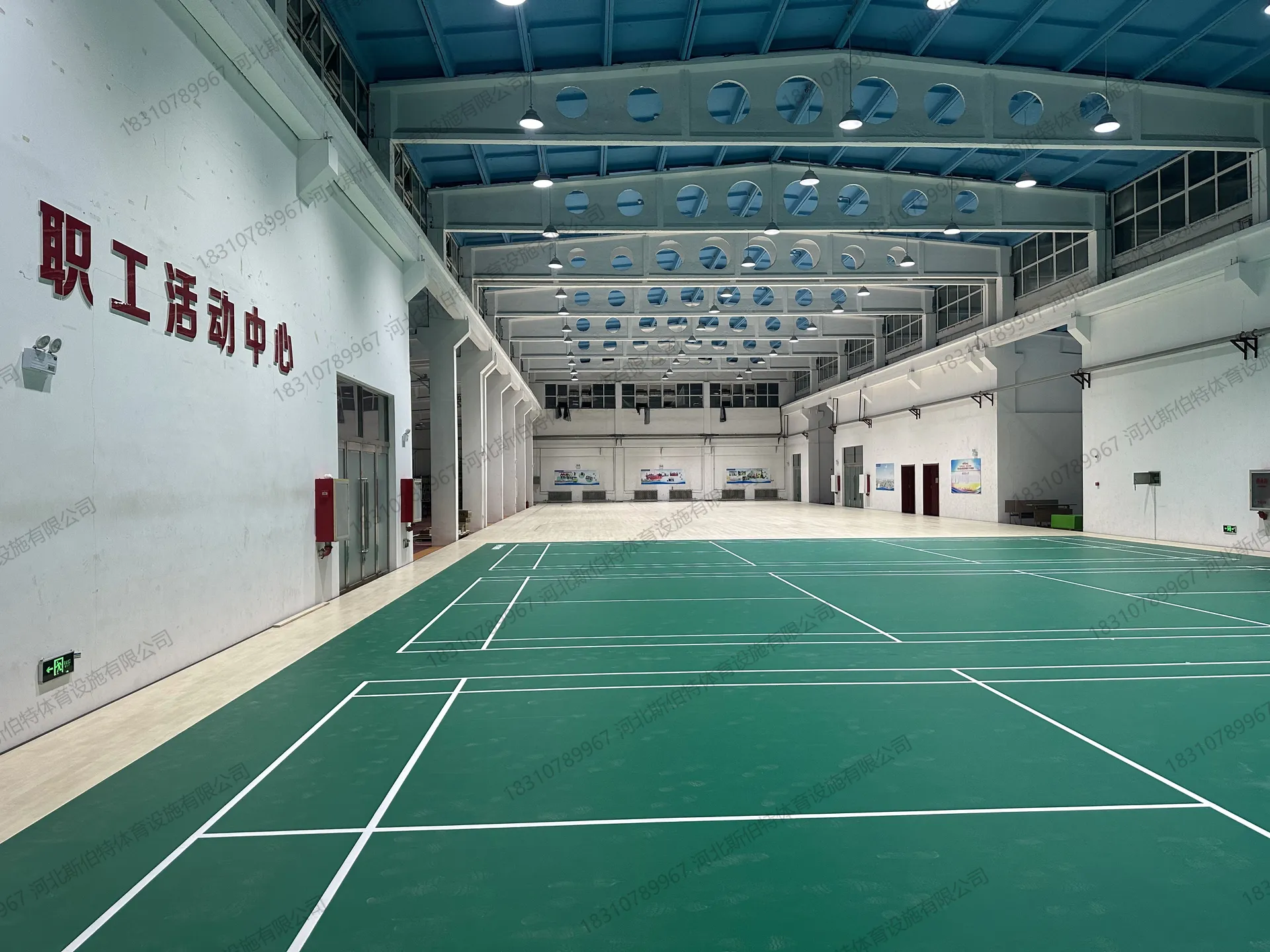 完工全景：左侧PVC地胶羽毛球区，右侧枫桦木木地板区，多功能分区清晰