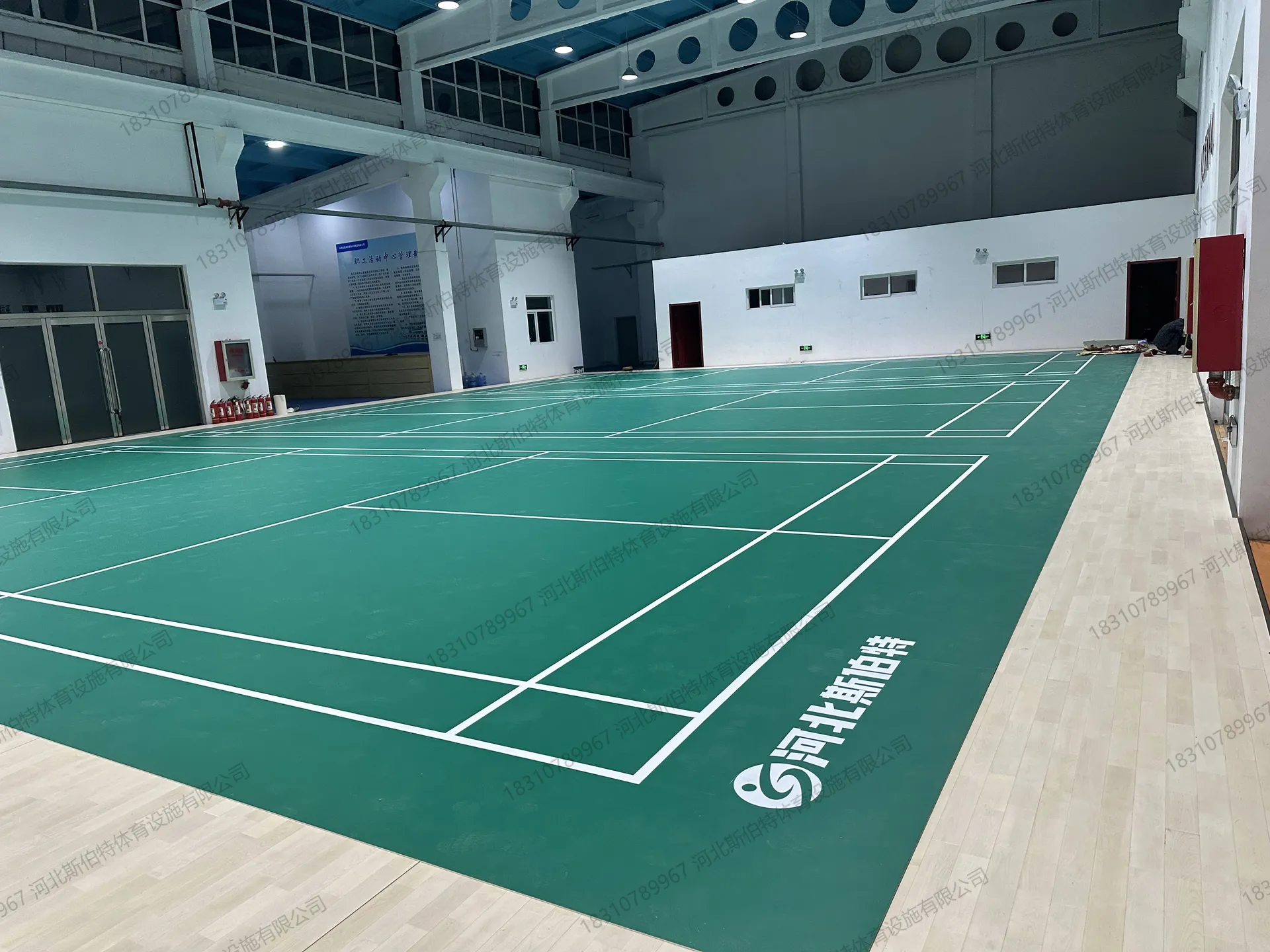 完工实景：PVC地胶羽毛球区，多片标准场地并列，白色标线清晰