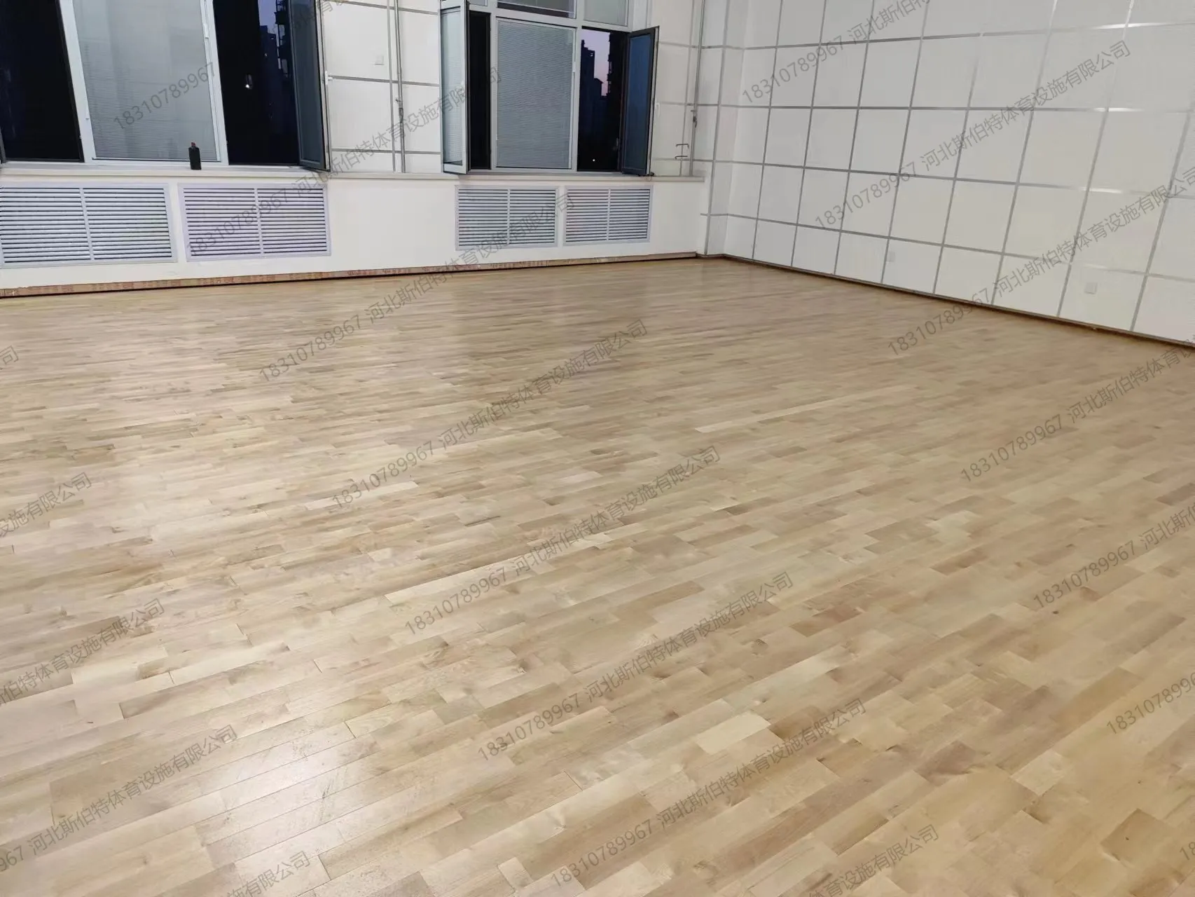 完工实景：枫桦木A级地板，浅木色暖黄调，漆面光泽均匀，场馆明亮