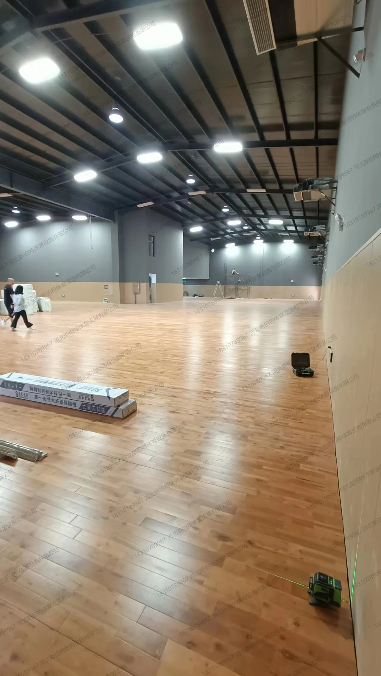 施工收尾:枫桦木C级地板铺满场地,漆面光泽适中,少量材料待清理