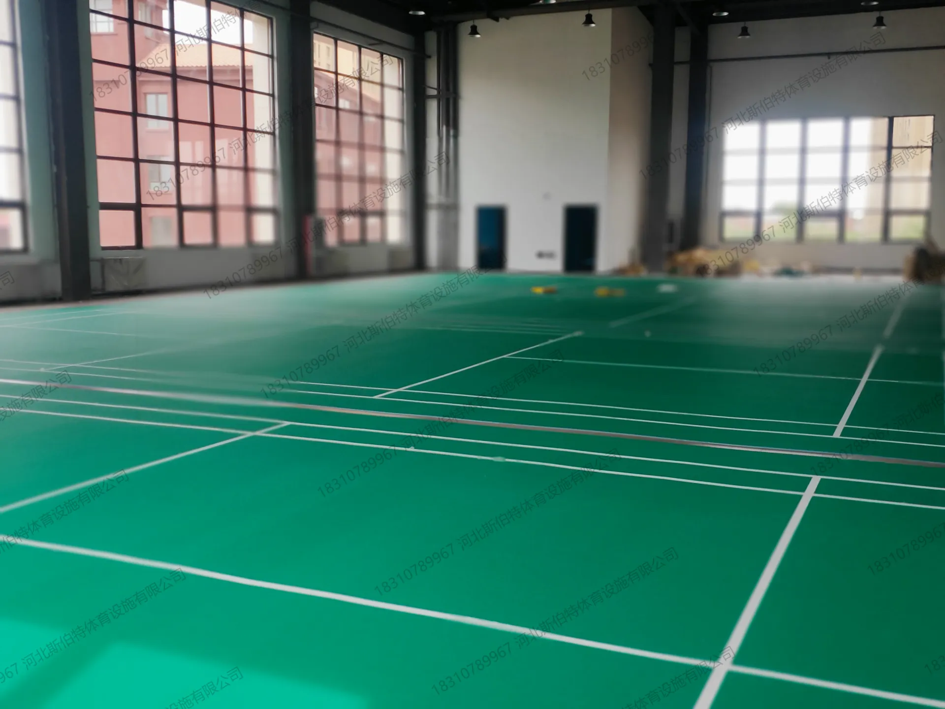 完工实景：室内羽毛球馆绿色运动地胶完工，白色标线完整，宽敞明亮