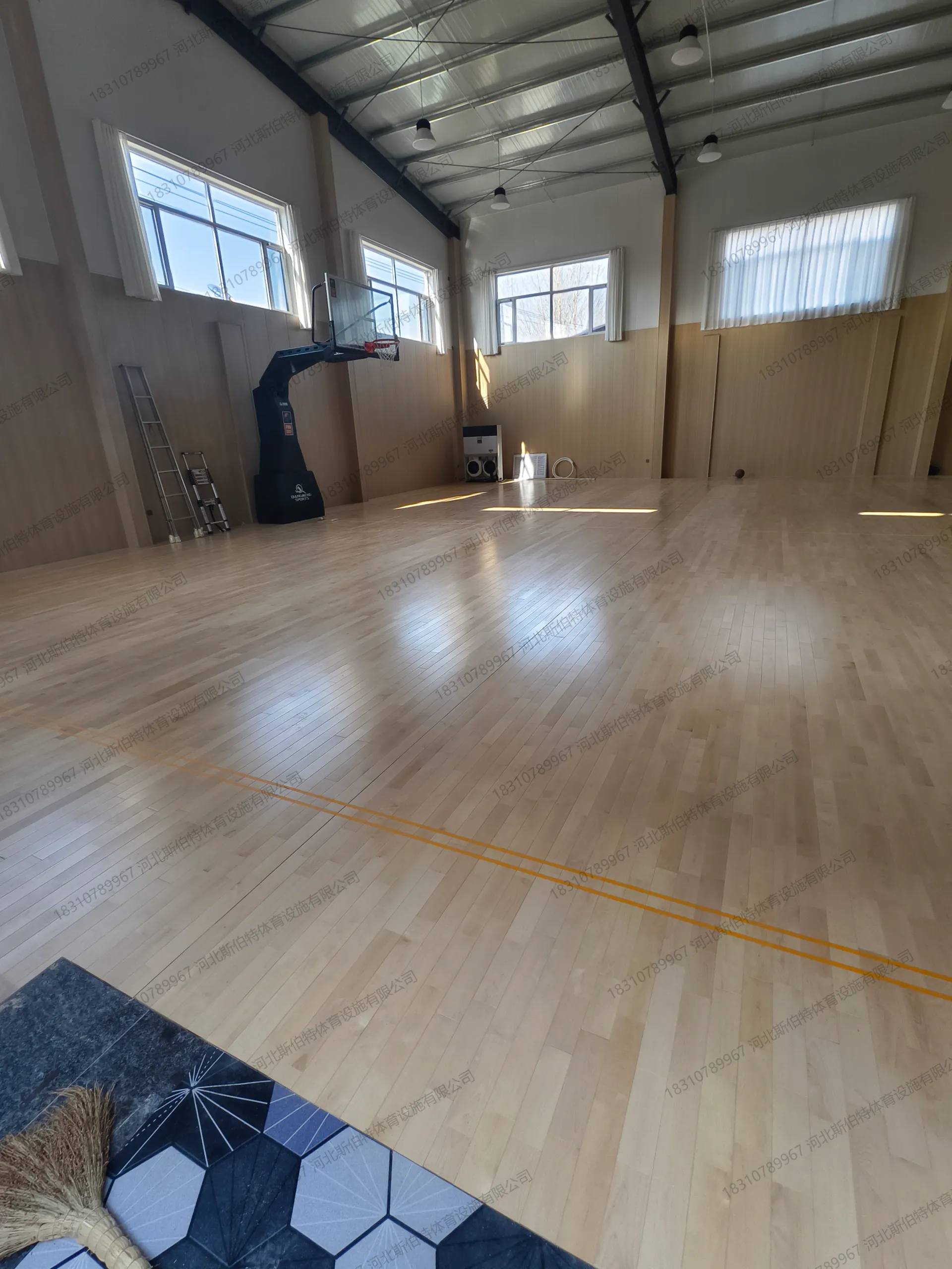 完工实景：枫桦木AB级地板铺装完成，黄色标线清晰，篮球架就位