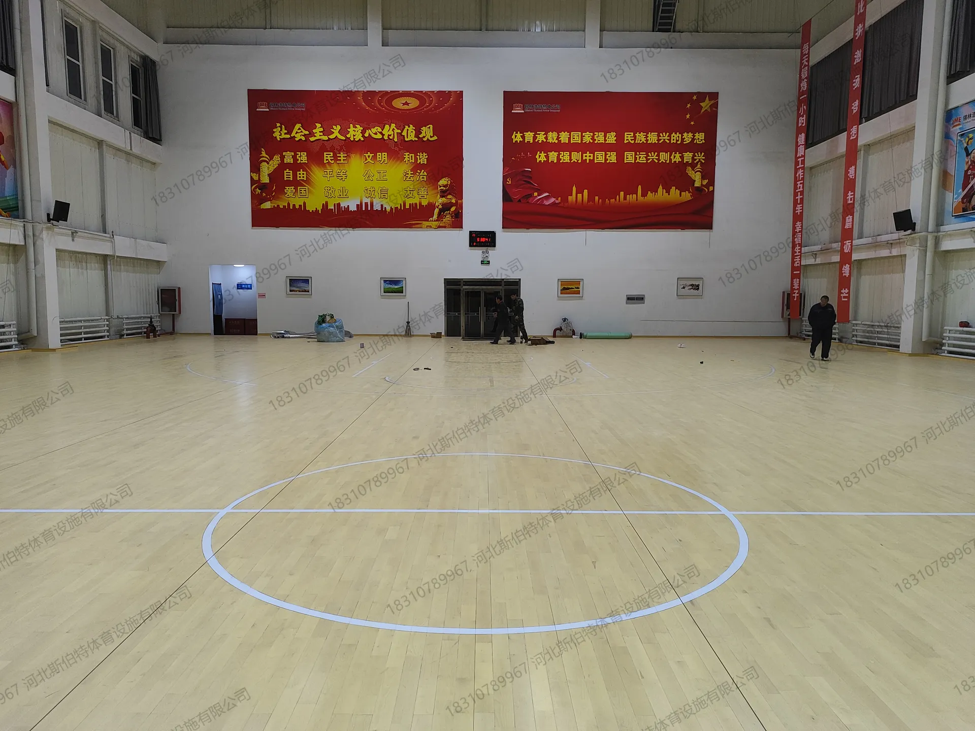 毛地板进场,工人搬运黑色板材准备铺设