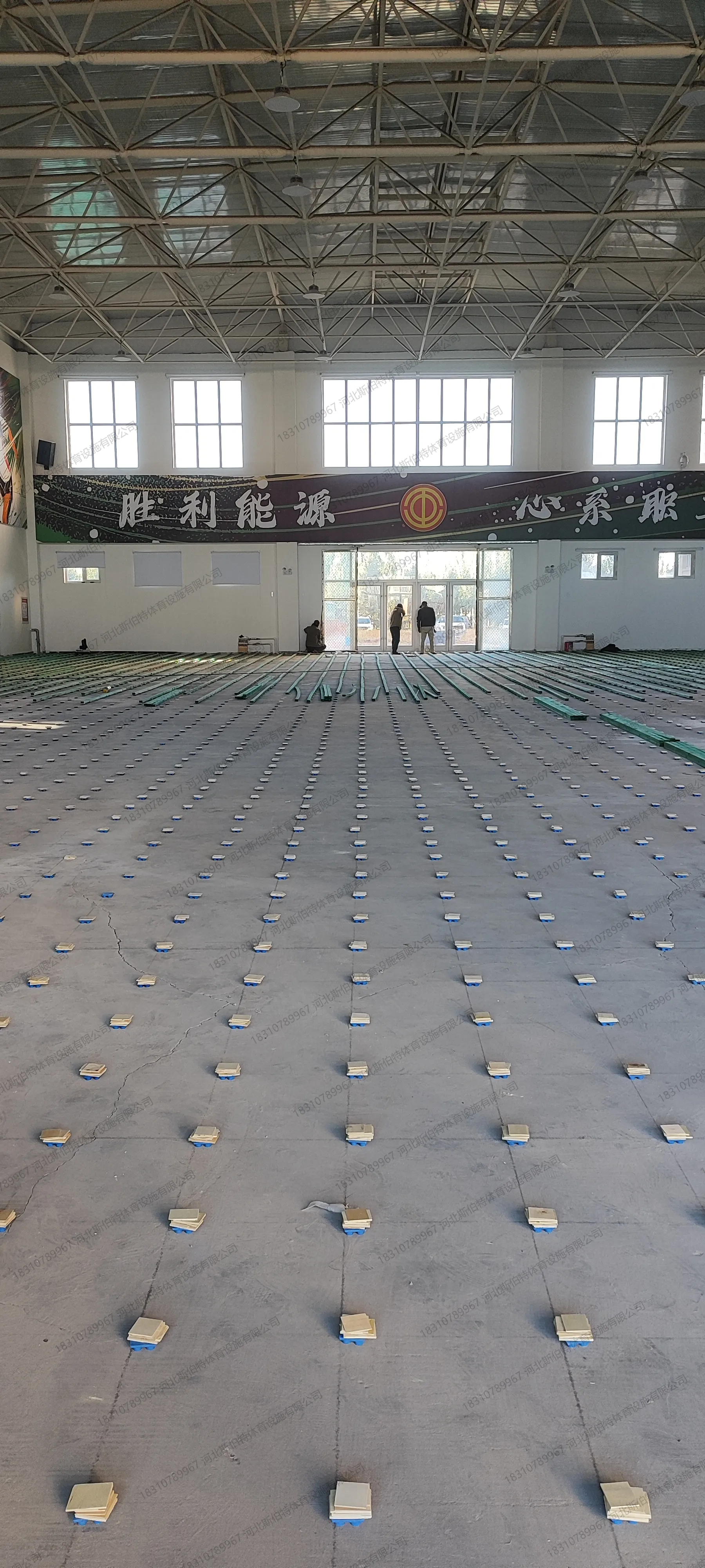 双层龙骨铺设中:30x50mm绿色龙骨排列,减震垫块调平