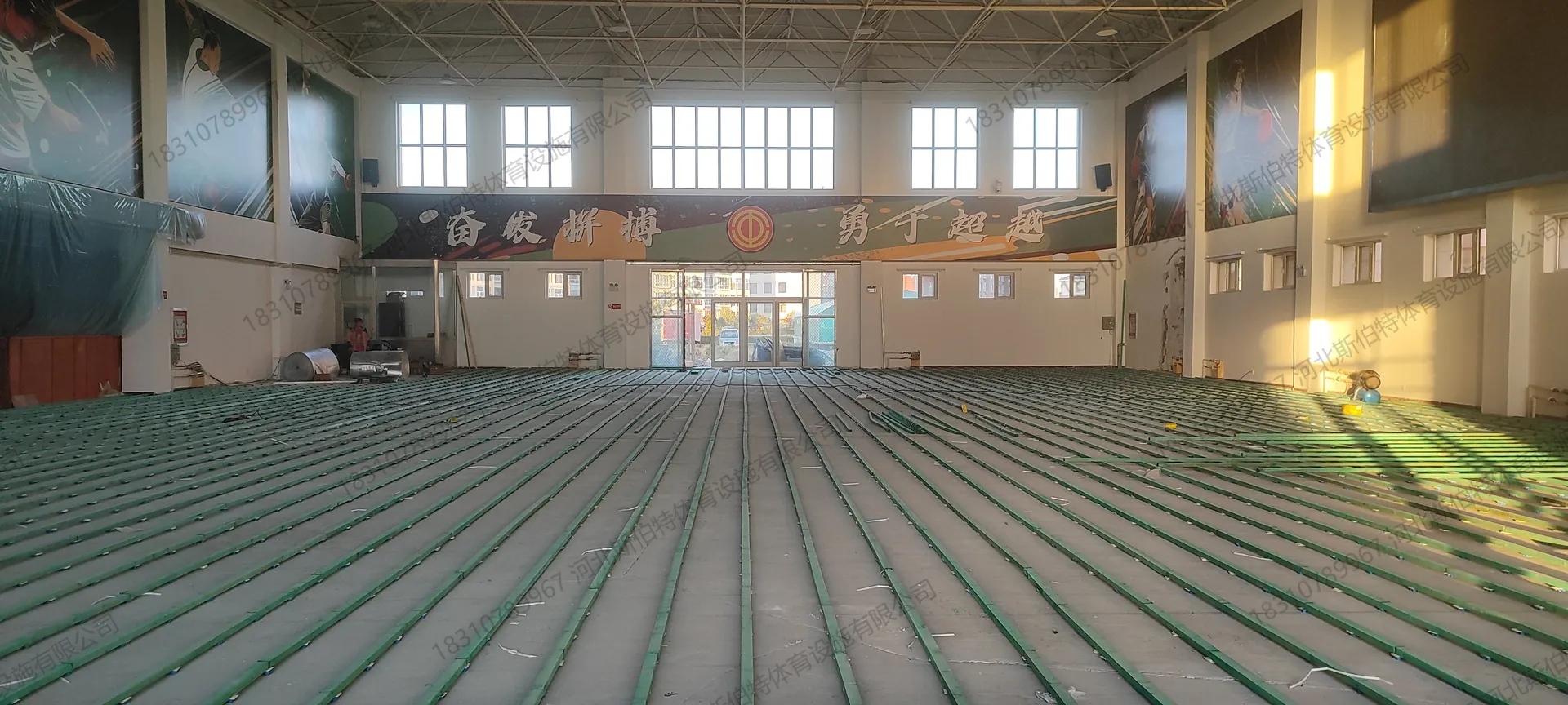 龙骨铺设完成:绿色双层龙骨网格铺满场地,空间开阔