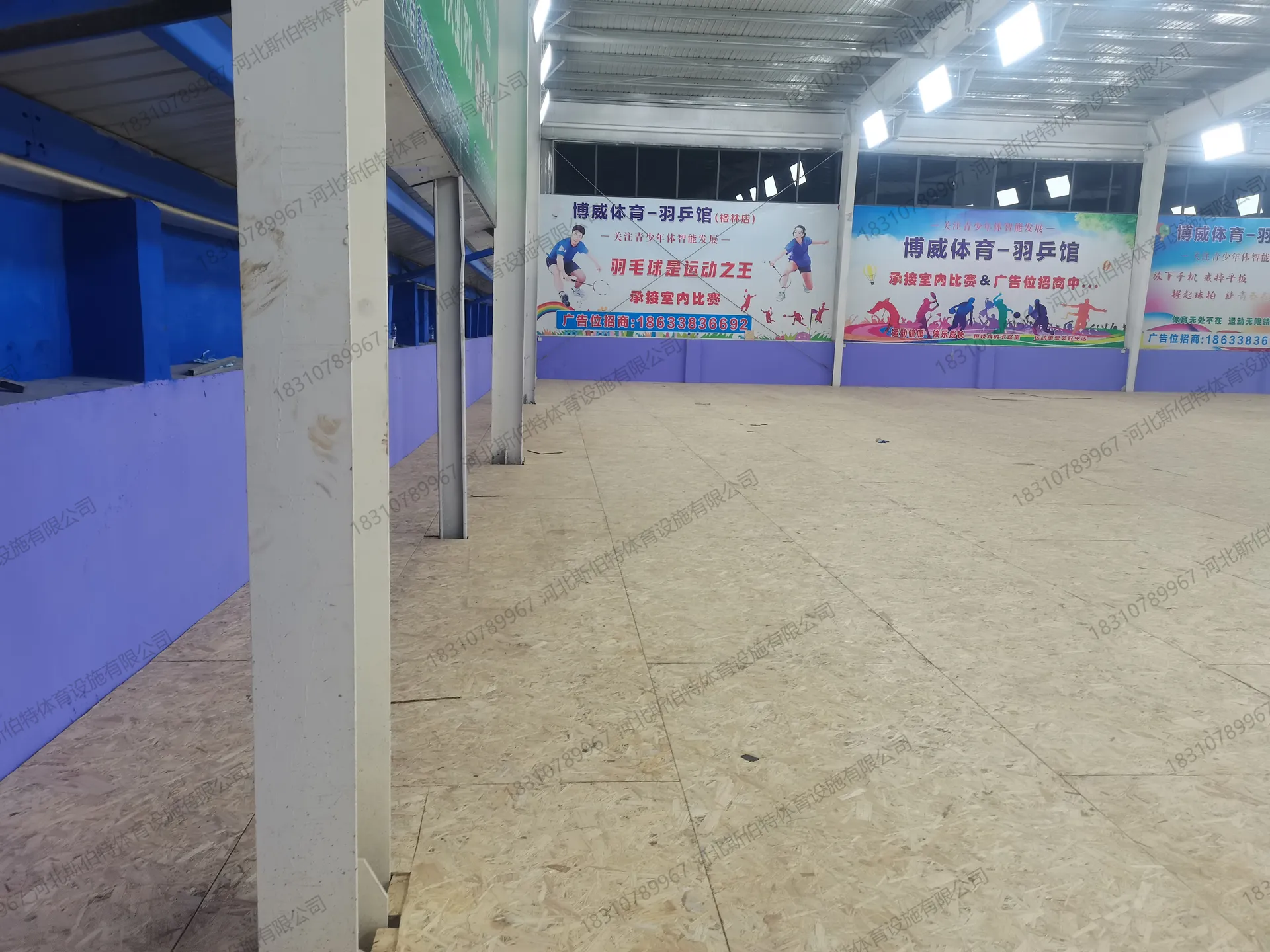 完工实景：地板铺装完成，空间开阔，钢屋架与LED灯阵就位