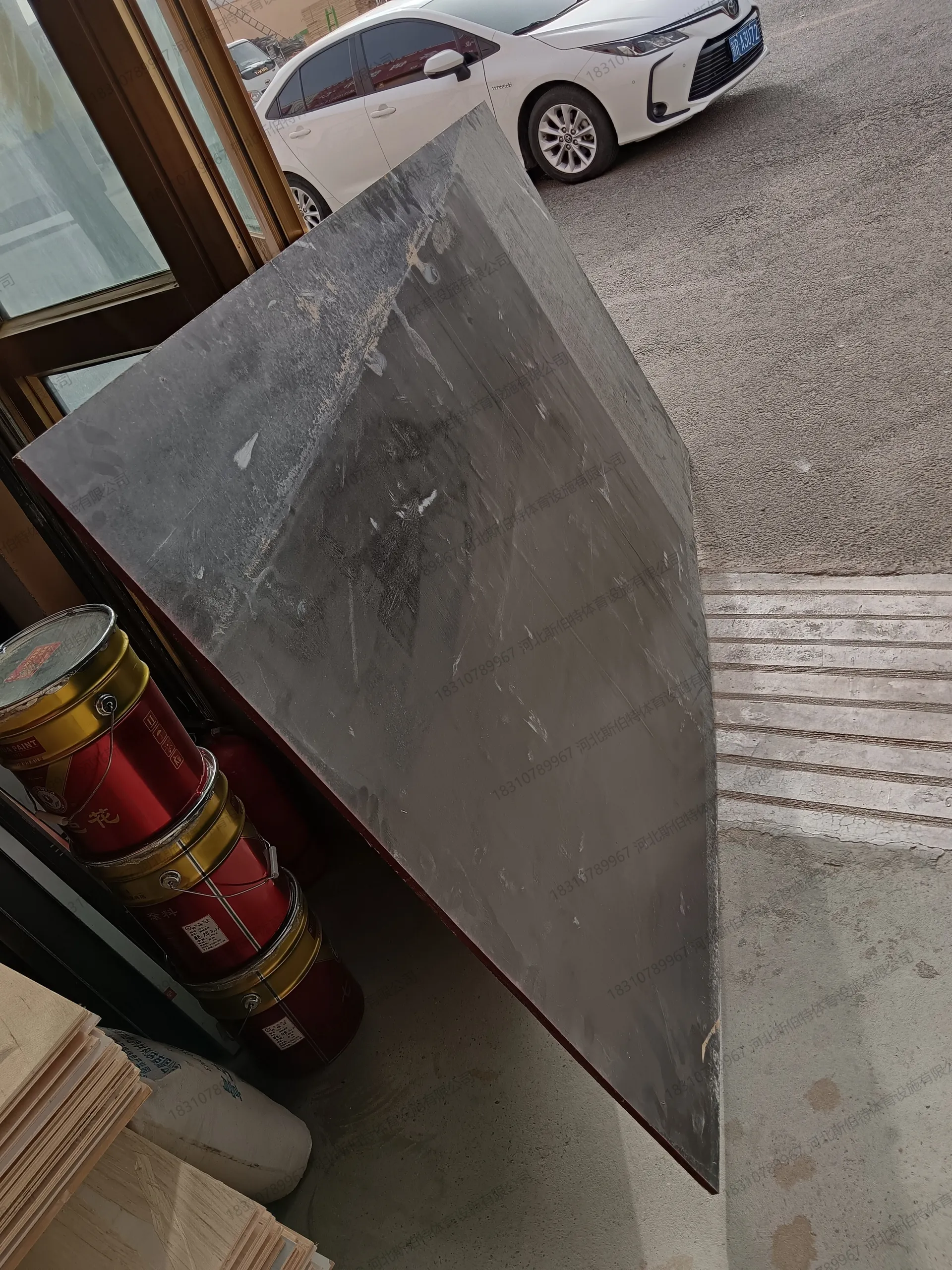 成品枫桦木面层地板板材进场，室内门口堆放，旁有三棵树工程漆