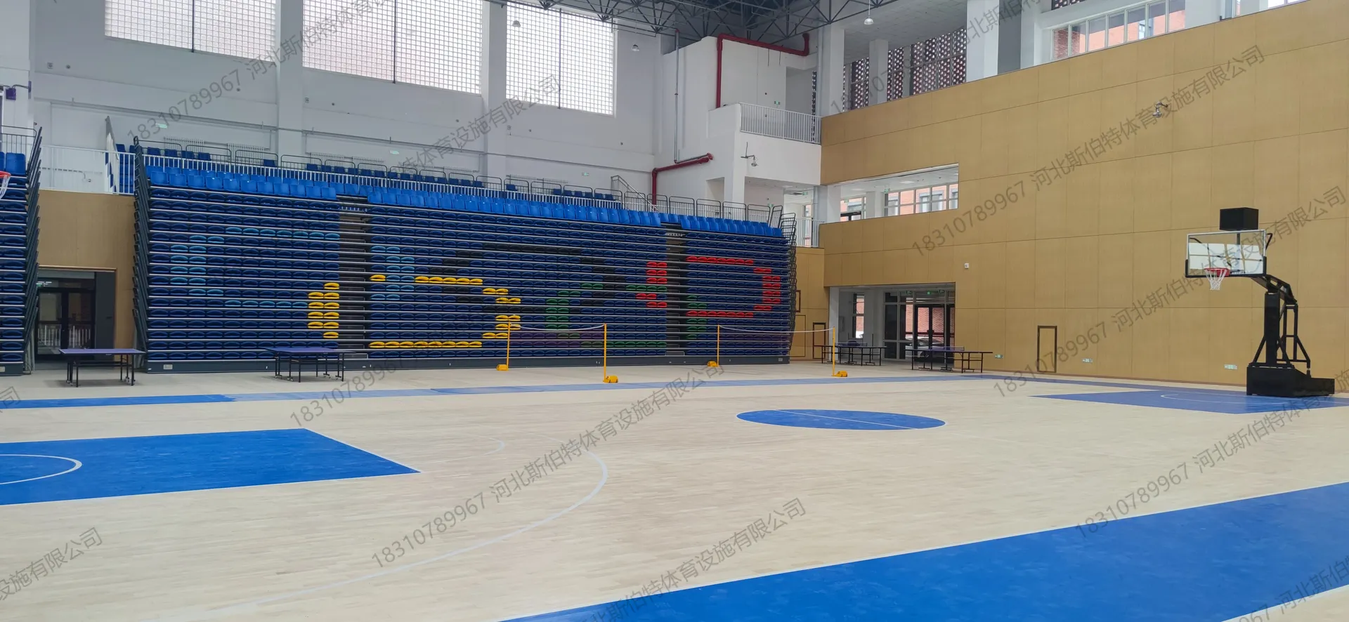 完工实景:篮球场启用,枫桦木地板斜铺完成,白色标线清晰,蓝色罚球区