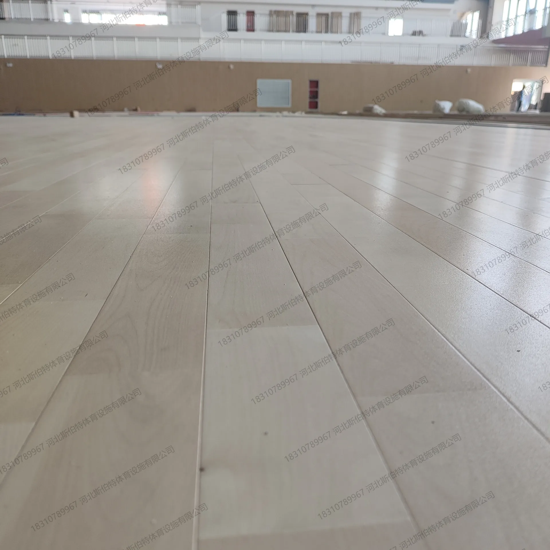 材料验收:包装标注"体育专用木地板",工人检查