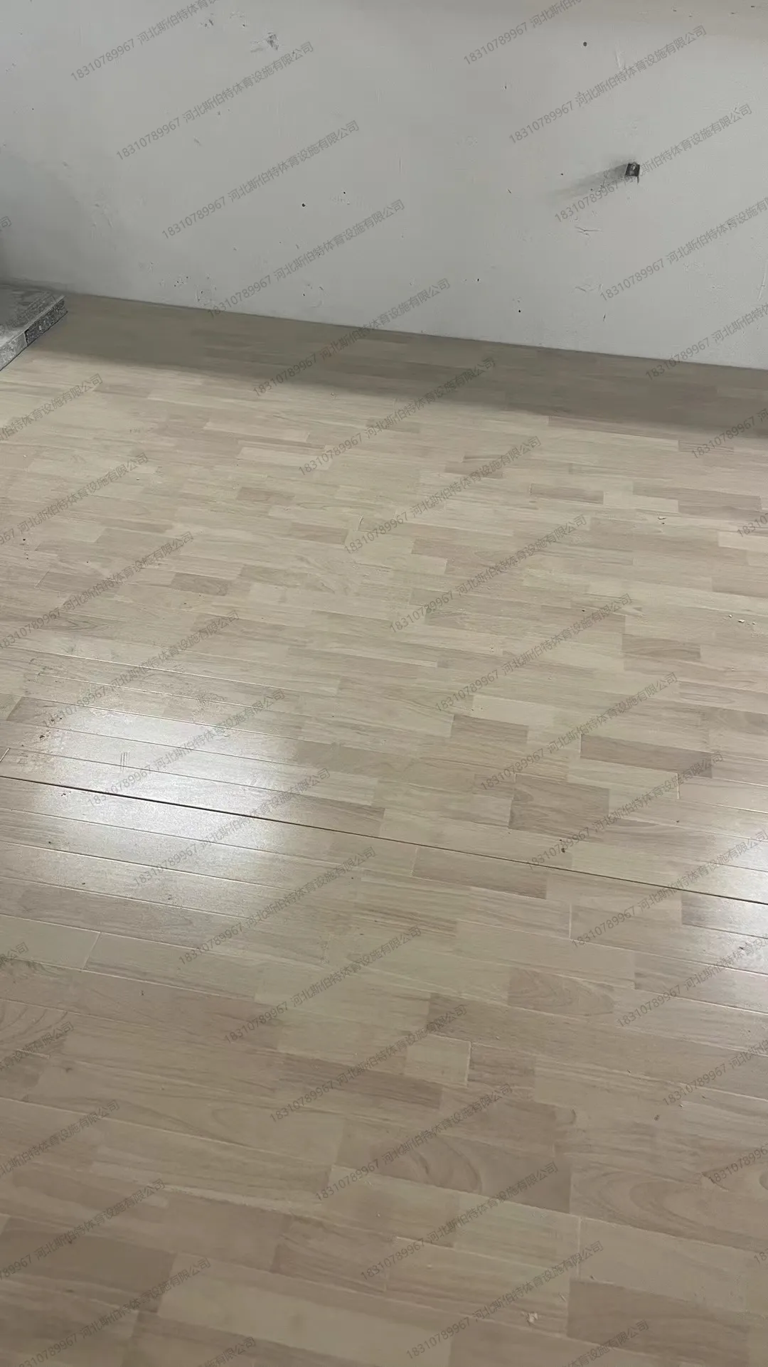 完工实景：橡胶木加色地板斜铺完成，浅棕色板缝对角线走向