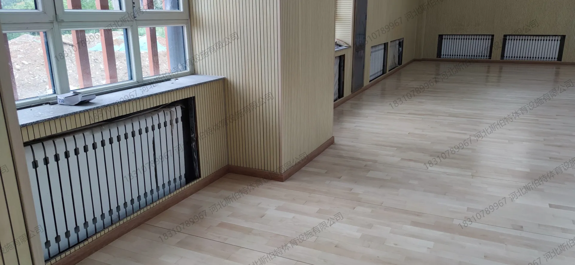 完工实景:篮球场白色标线清晰,浅木色地板反光均匀
