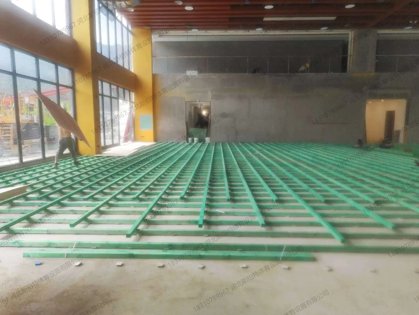 施工过程：双层龙骨框架搭建，绿色龙骨纵横交错