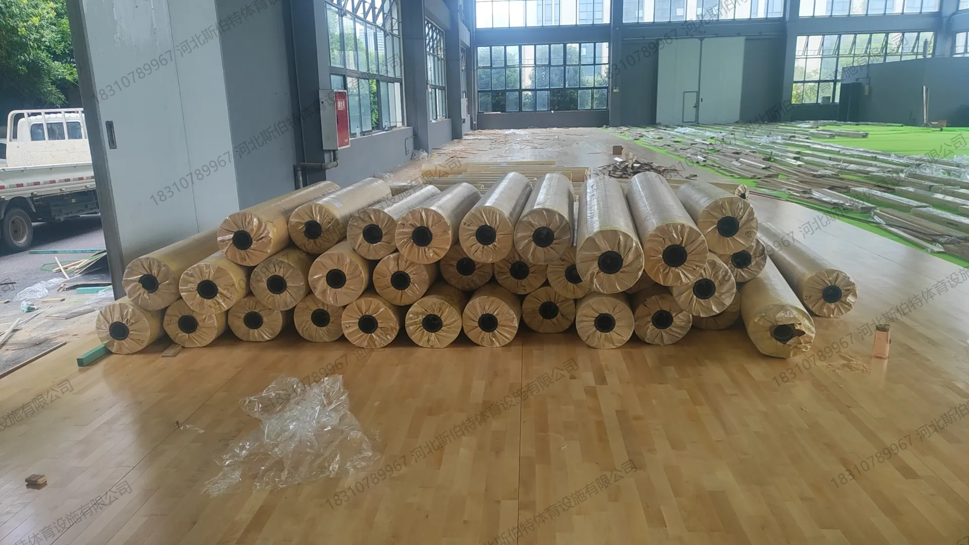 材料进场阶段：地板卷材堆叠，场地开阔