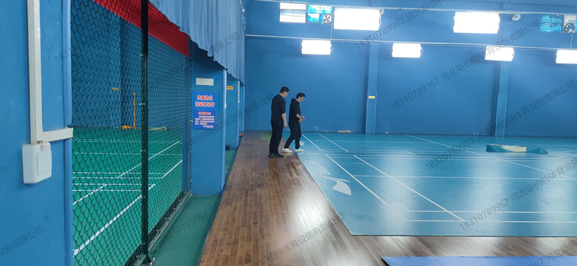 完工实景:PVC地胶羽毛球区,蓝色地胶配白色标线,YONEX品牌标志,专业比赛场地
