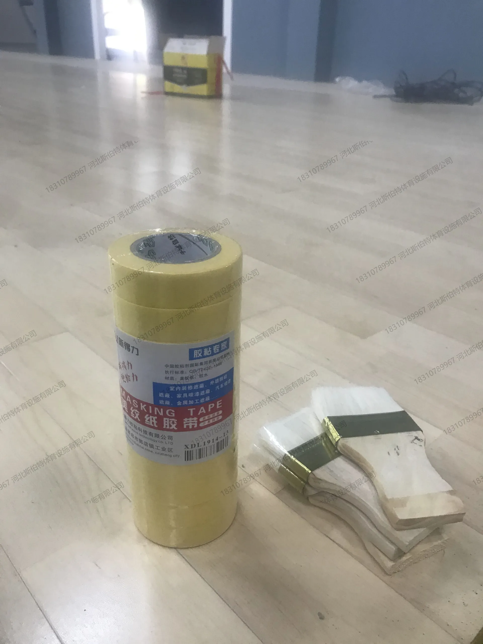施工过程：划线阶段，地板铺装完成，美纹纸胶带辅助划线，工人作业中