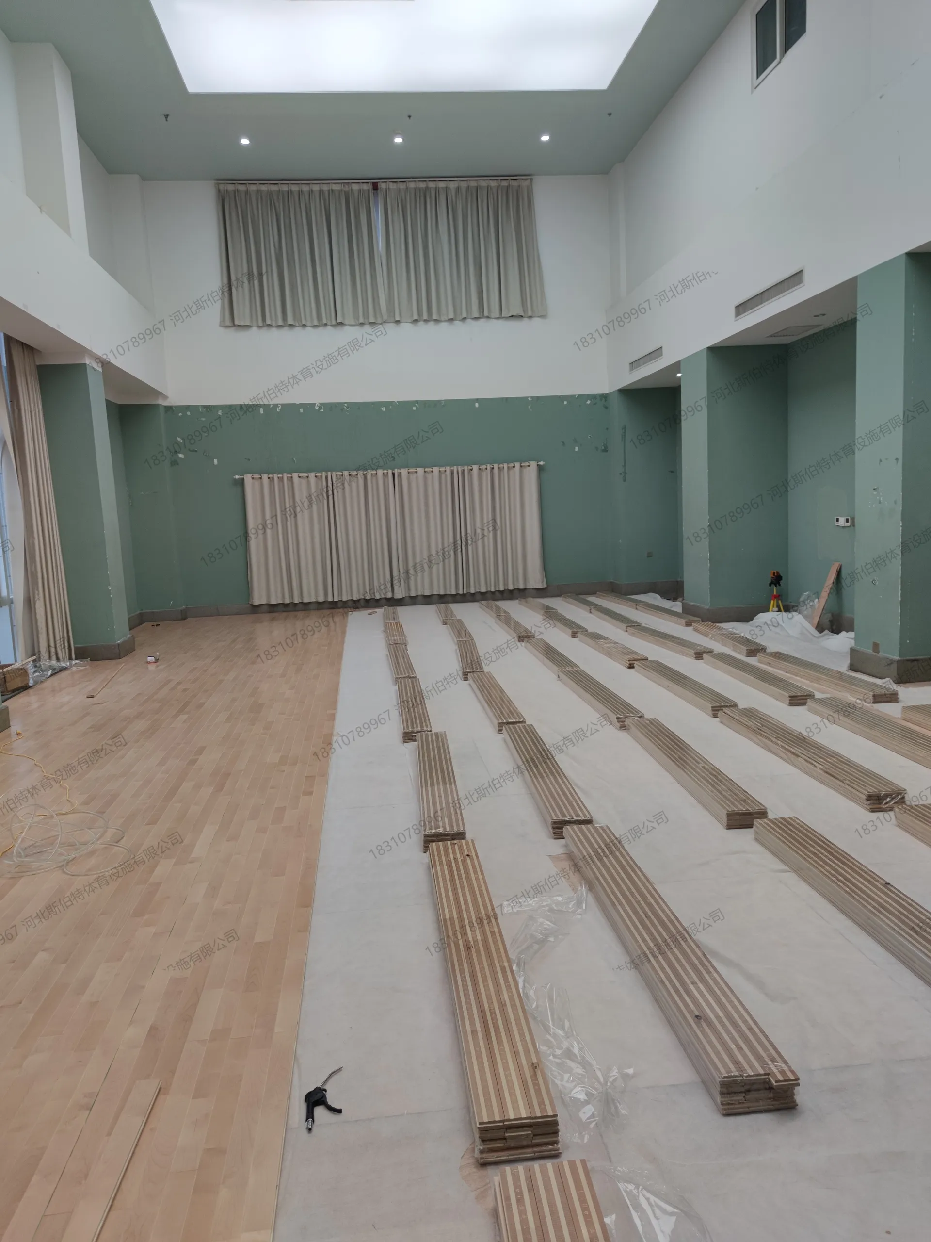 施工过程：双龙骨铺设中，底层横向龙骨与上层纵向龙骨交错，网格结构成型，远处工人作业