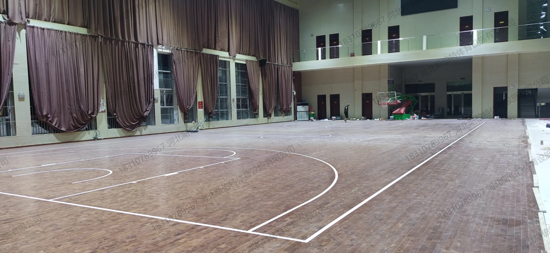 完工实景:枫桦木C级大节疤地板铺装完成,篮球场标线清晰,三分弧线与中圈完整,浅绿色墙面配深棕色窗帘